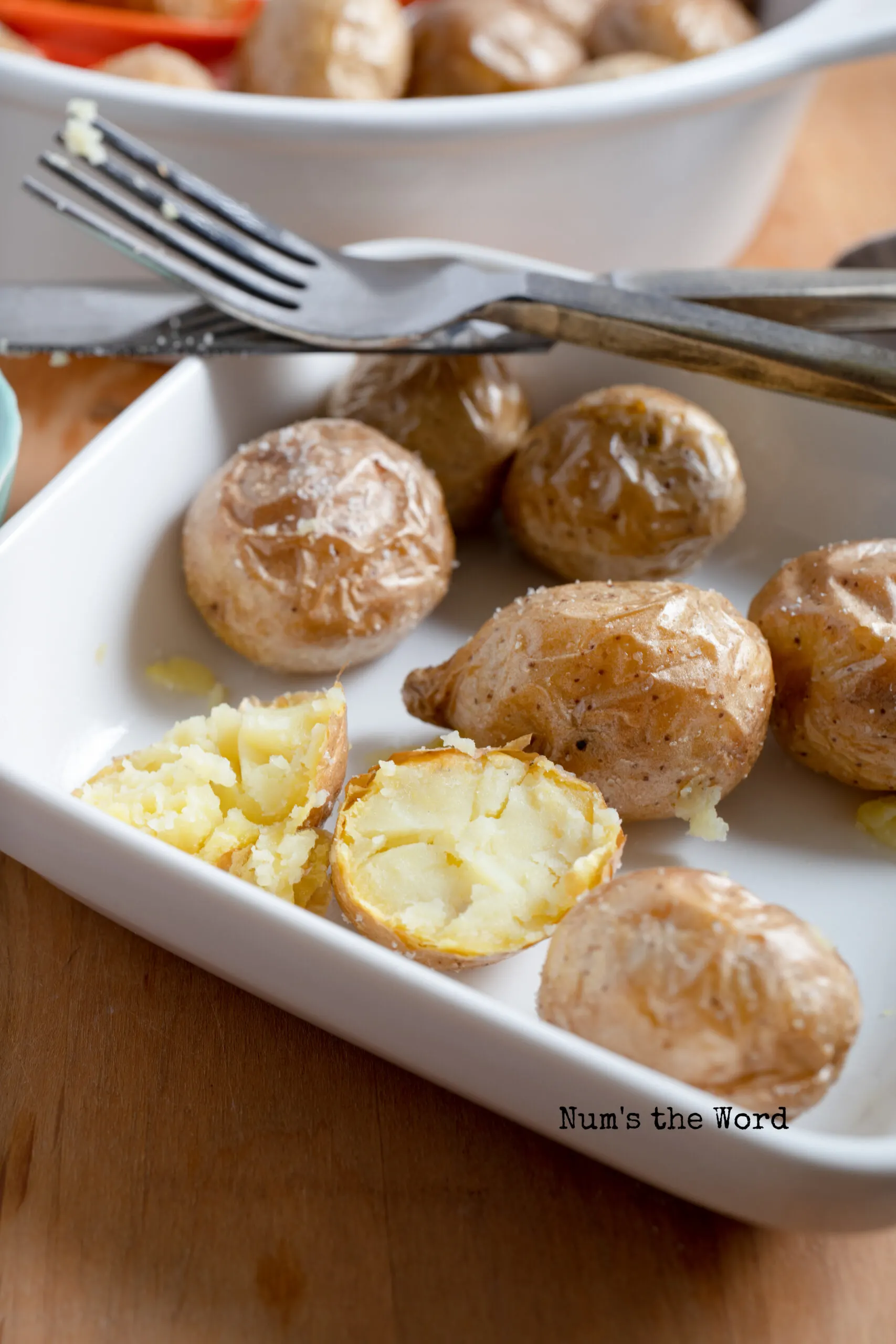 a plate with baby potatoes on it and one is cut in half.