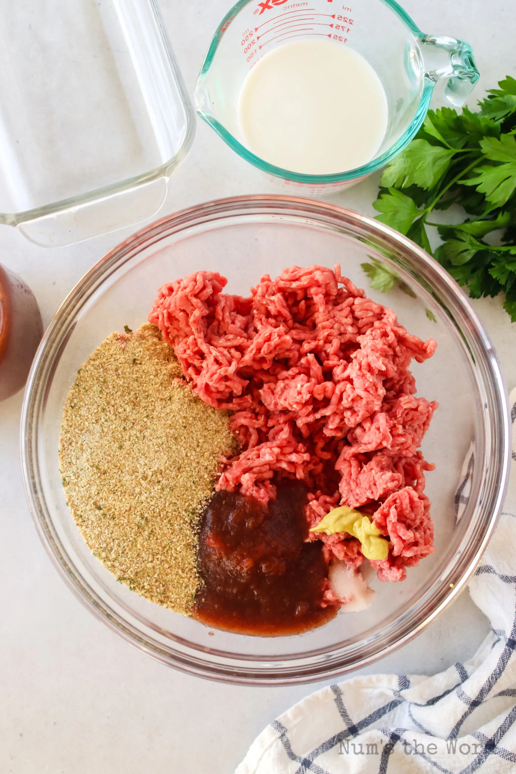 ground beef, applesauce, bread crumbs, salt and dijon mustard in a bowl, unmixed.