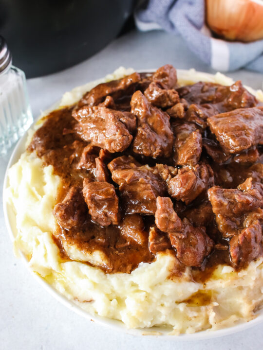 zoomed in image of beef tips over mashed potatoes
