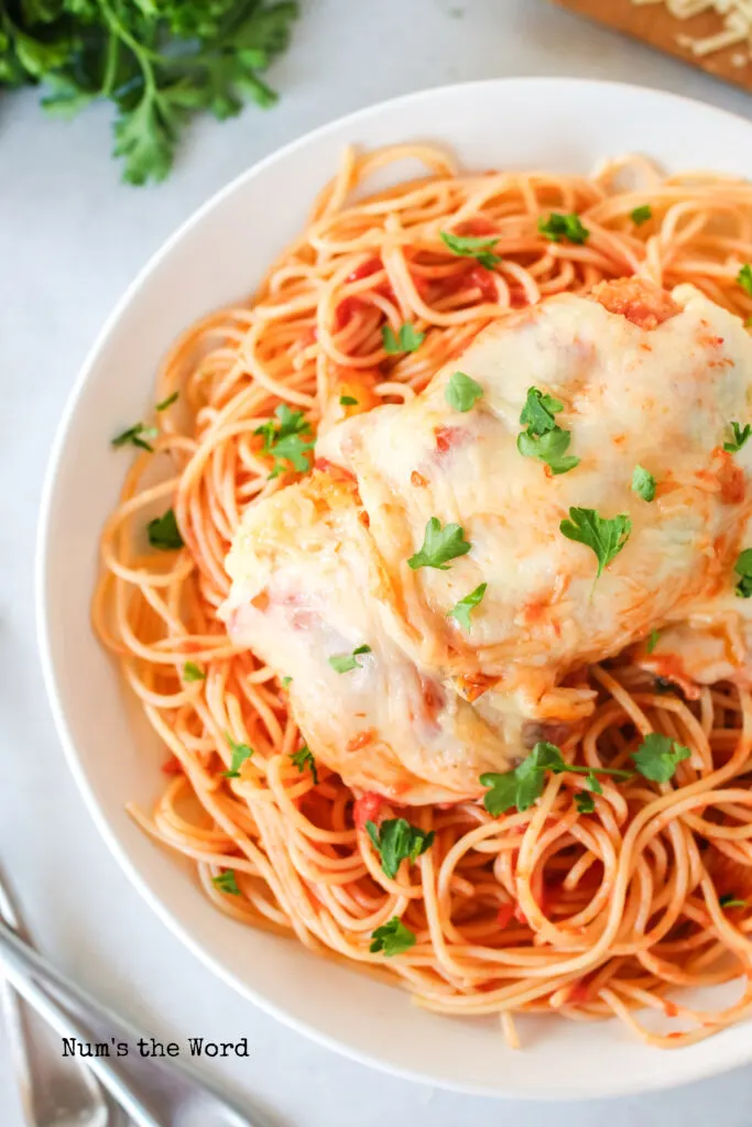 pasta in a bowl topped with a chicken breast