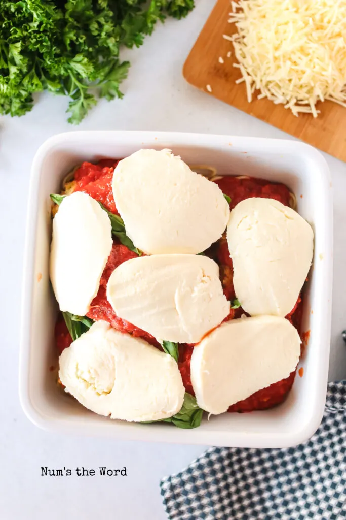 slices of fresh mozzarealla placed on top of basil and chicken