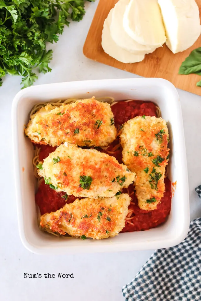 Fried parmesan chicken placed on top of marinara sauce