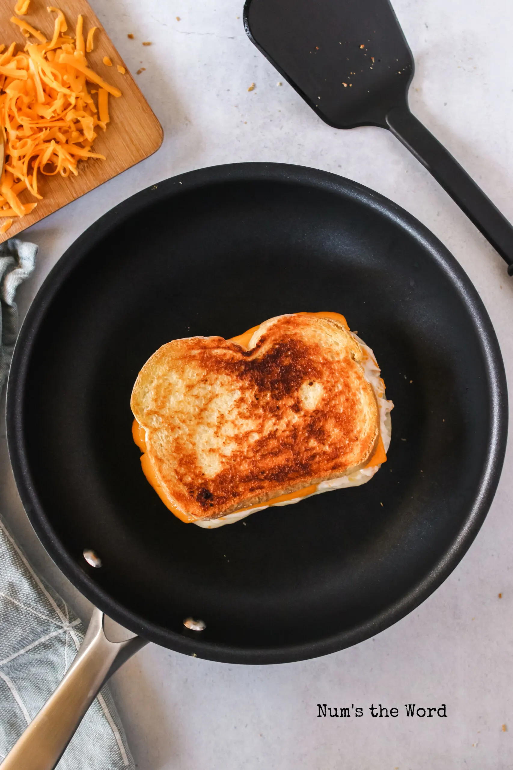 toasted grilled cheese flipped and cooking second side.