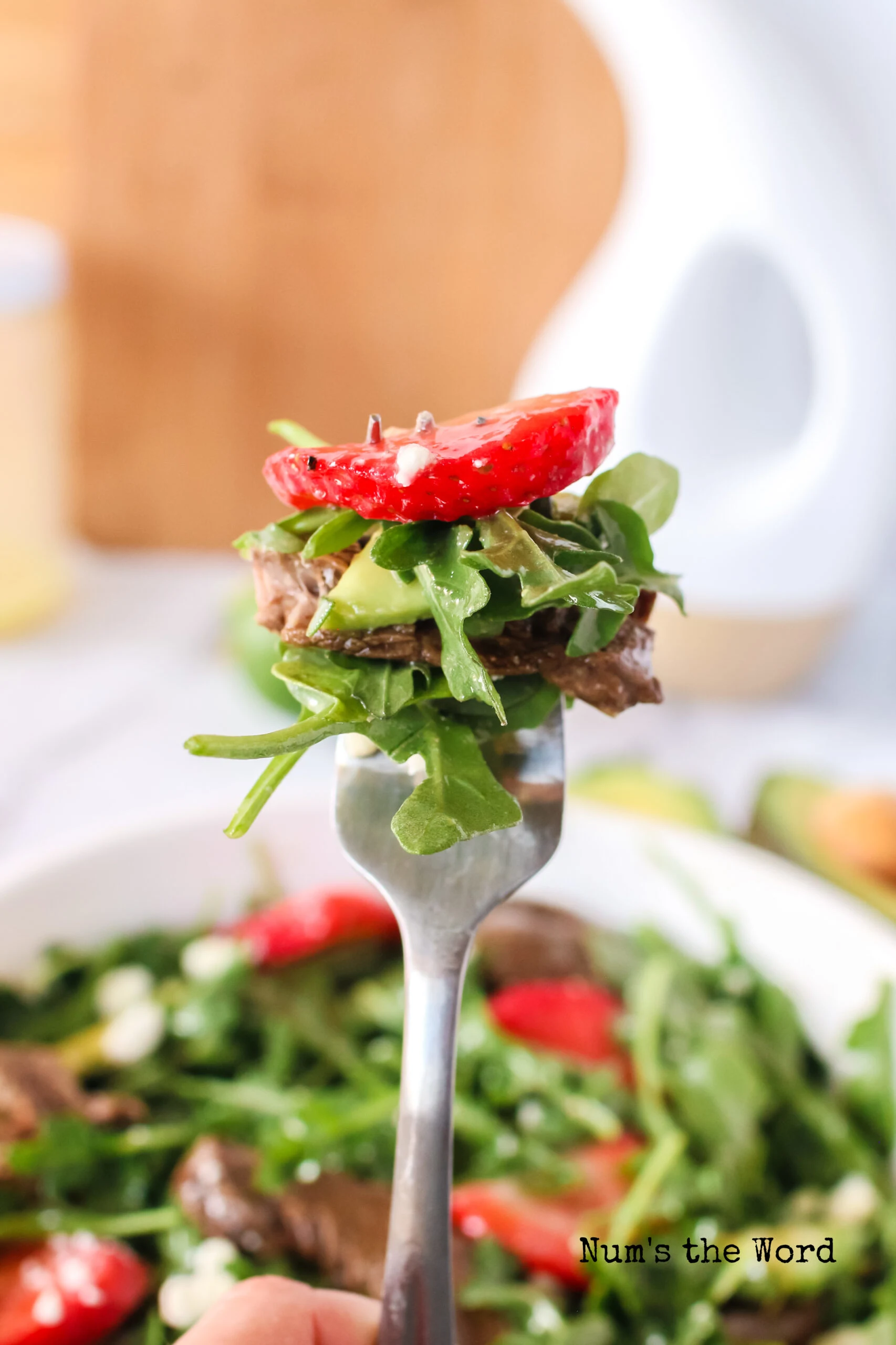 a fork full of salad, ready to eat.