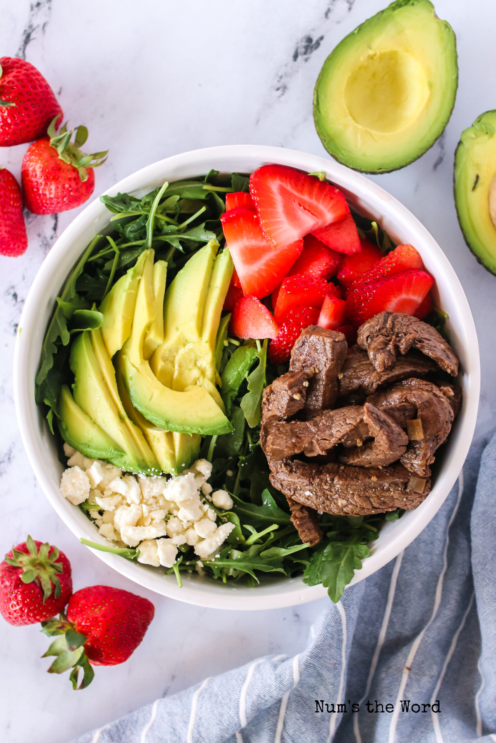 All ingredients for steak salad, minus the dressing, in a bowl, ready to mix.