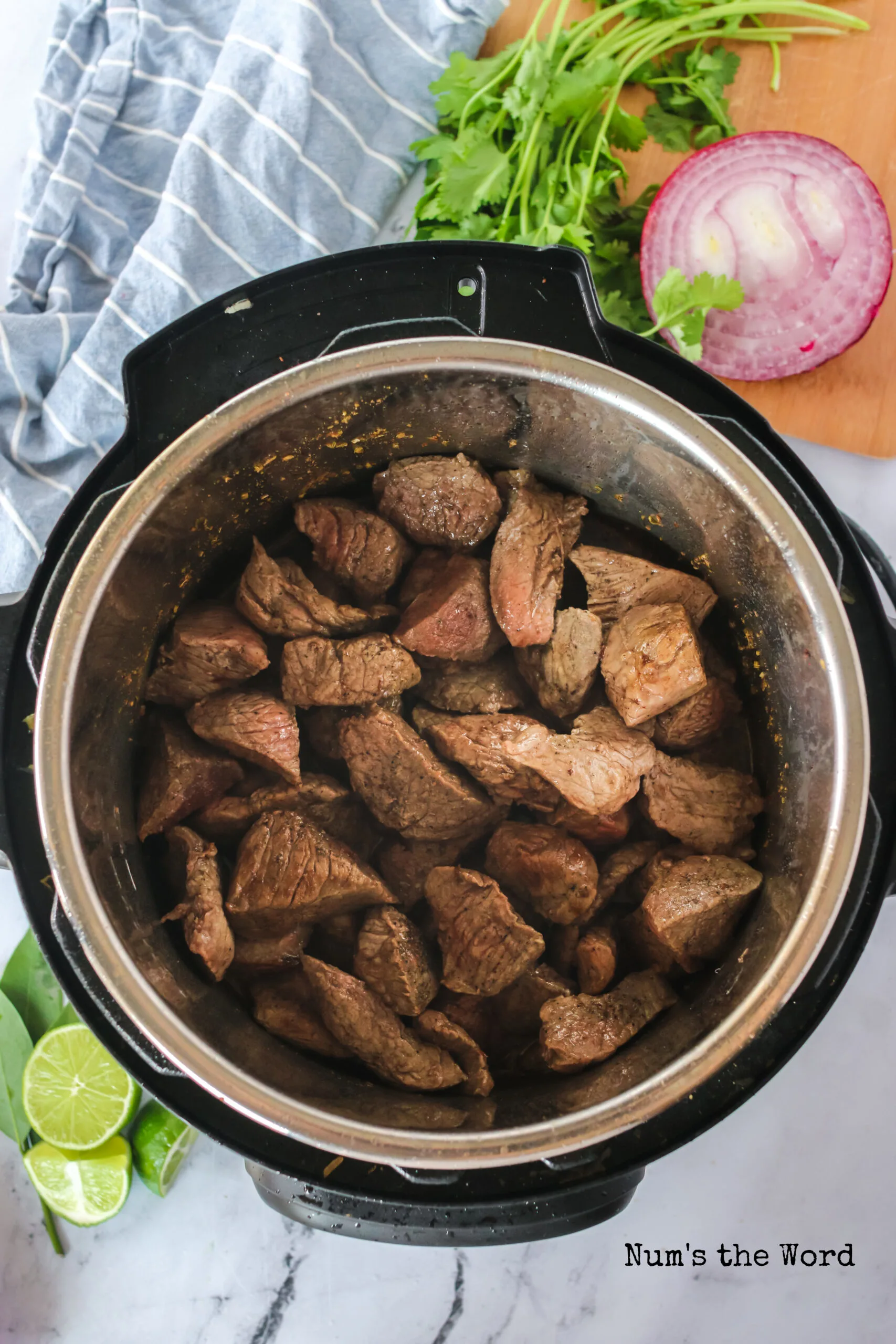 seared stew beef added back into the instant pot with liquid.