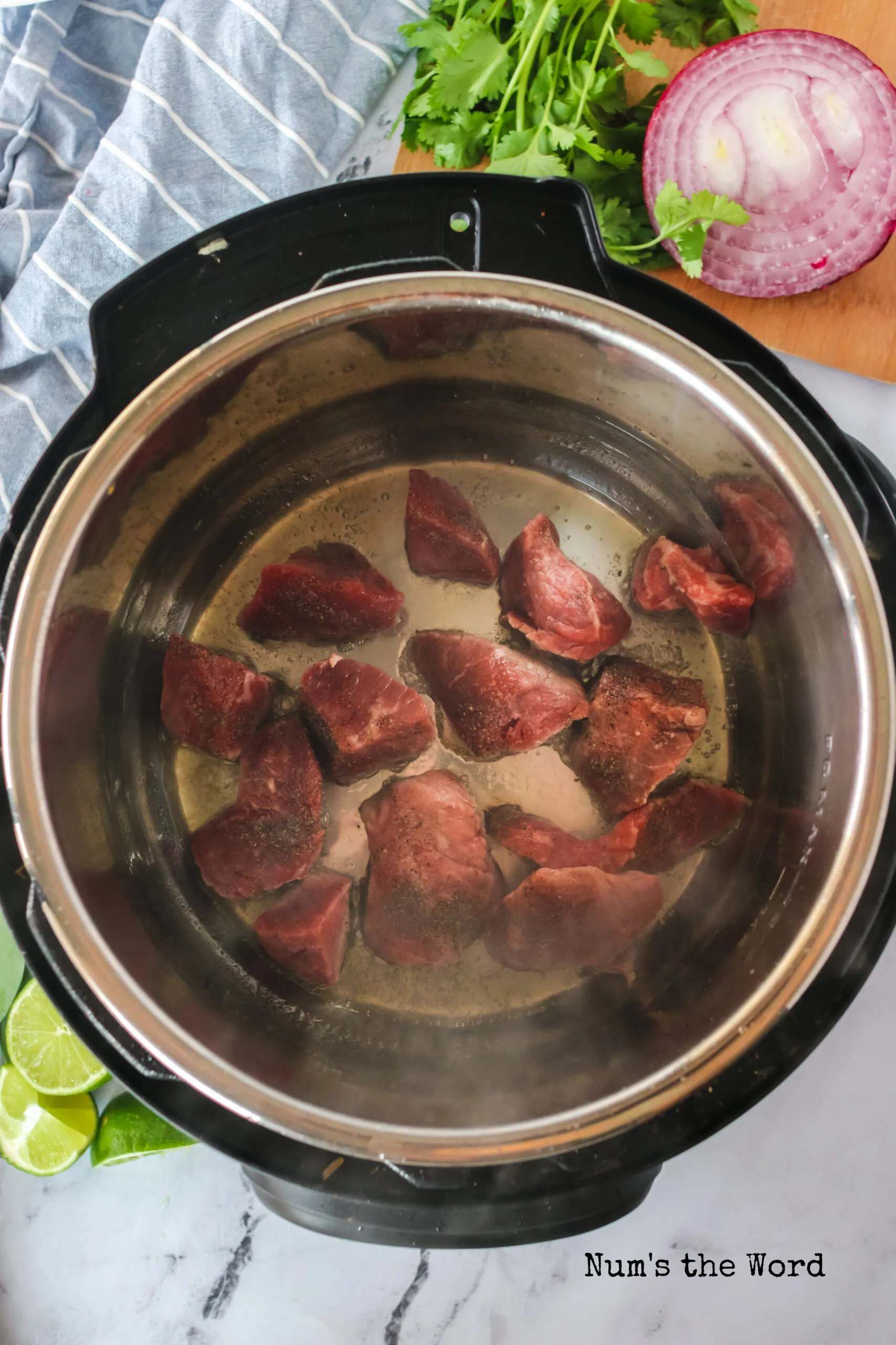 Stew beef chunks placed in the instant pot to sear.