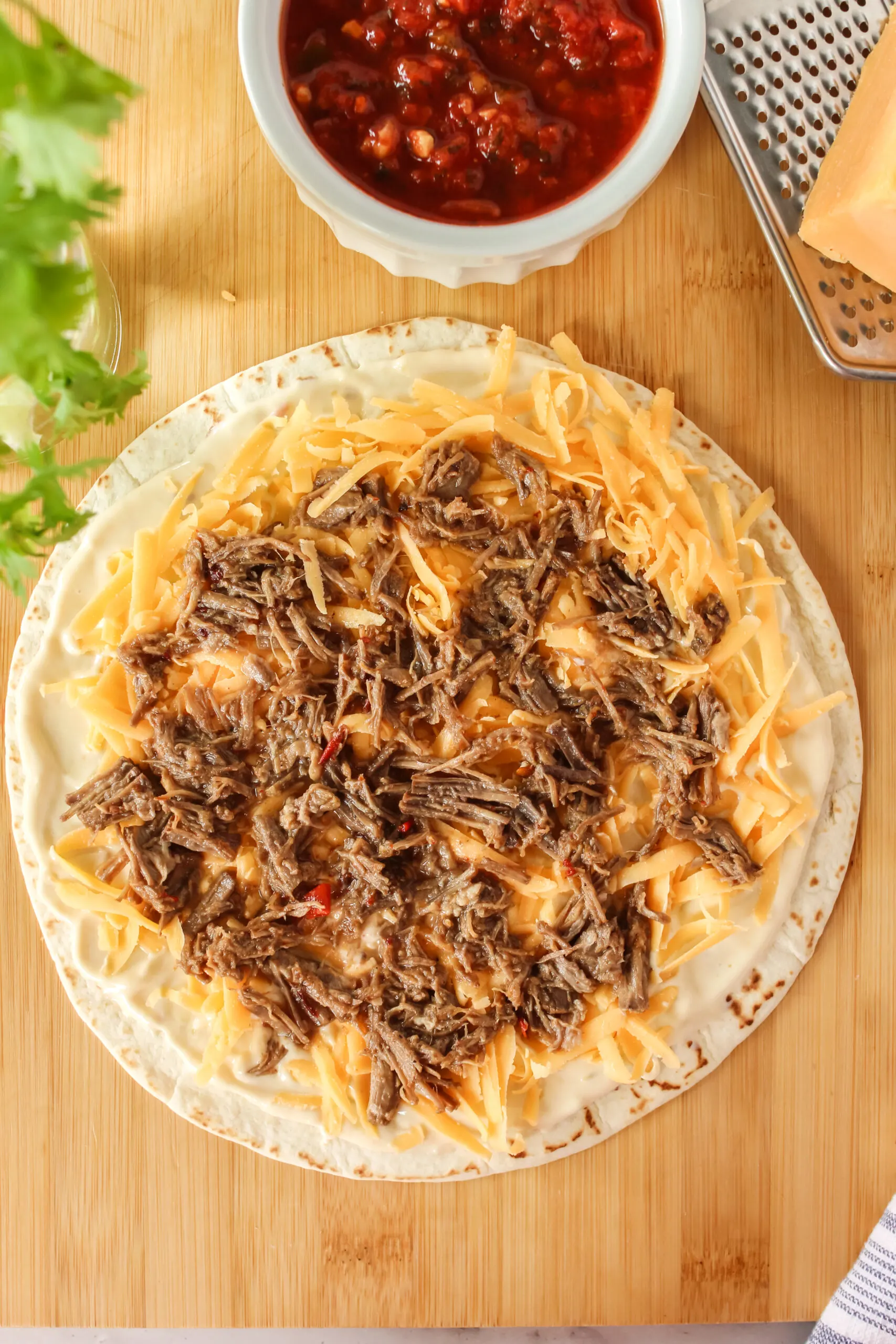 barbacoa beef placed on top of cheese