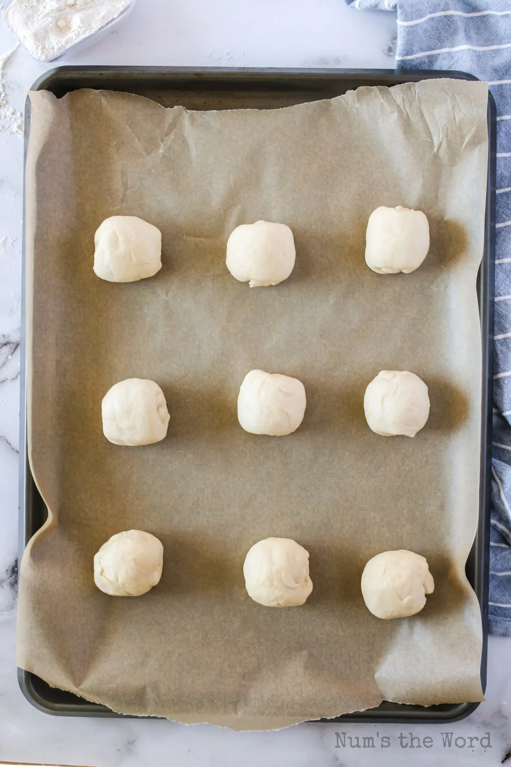 9 rolls placed on a lined cookie sheet.
