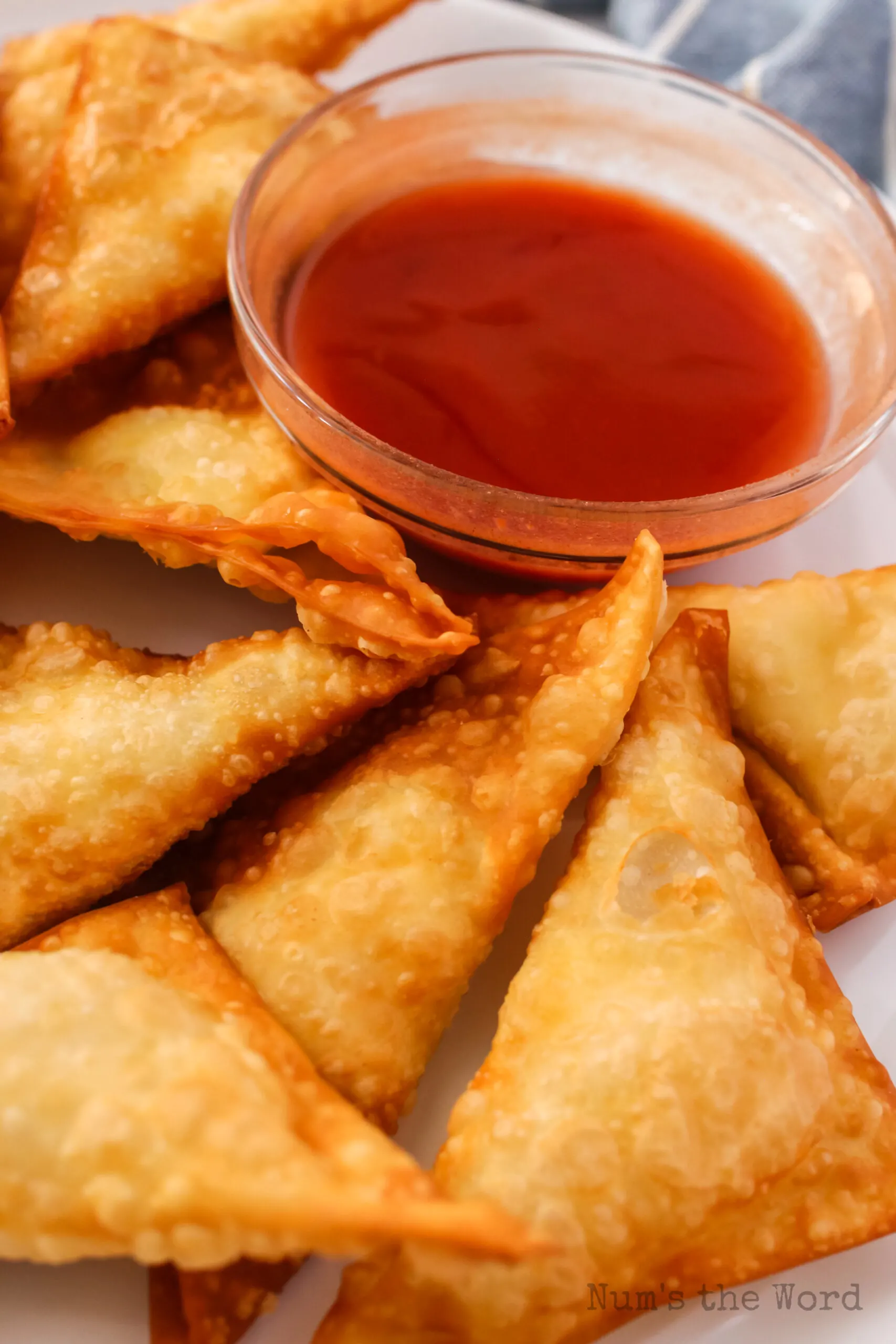 zoomed in image of cream cheese wontons on platter with dipping sauce