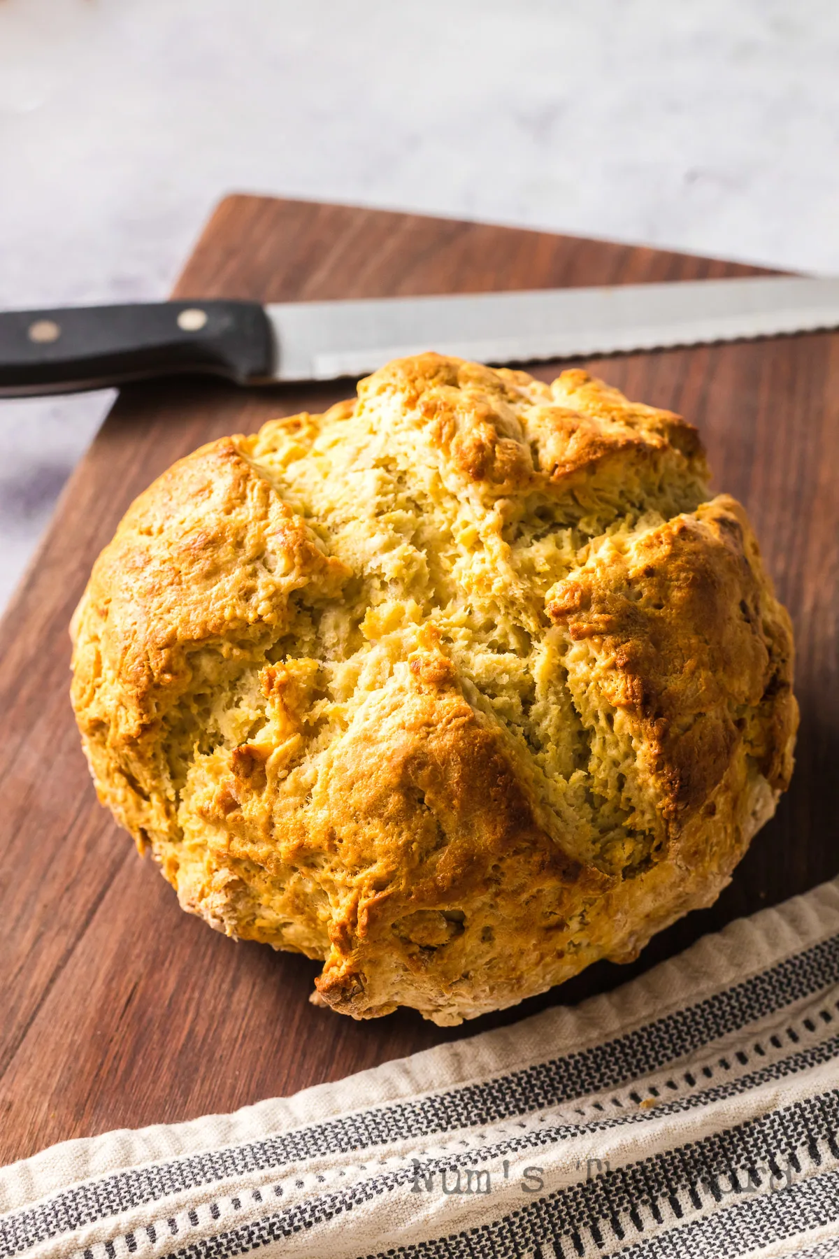 zoomed in angled view of loaf of bread on cutting board.