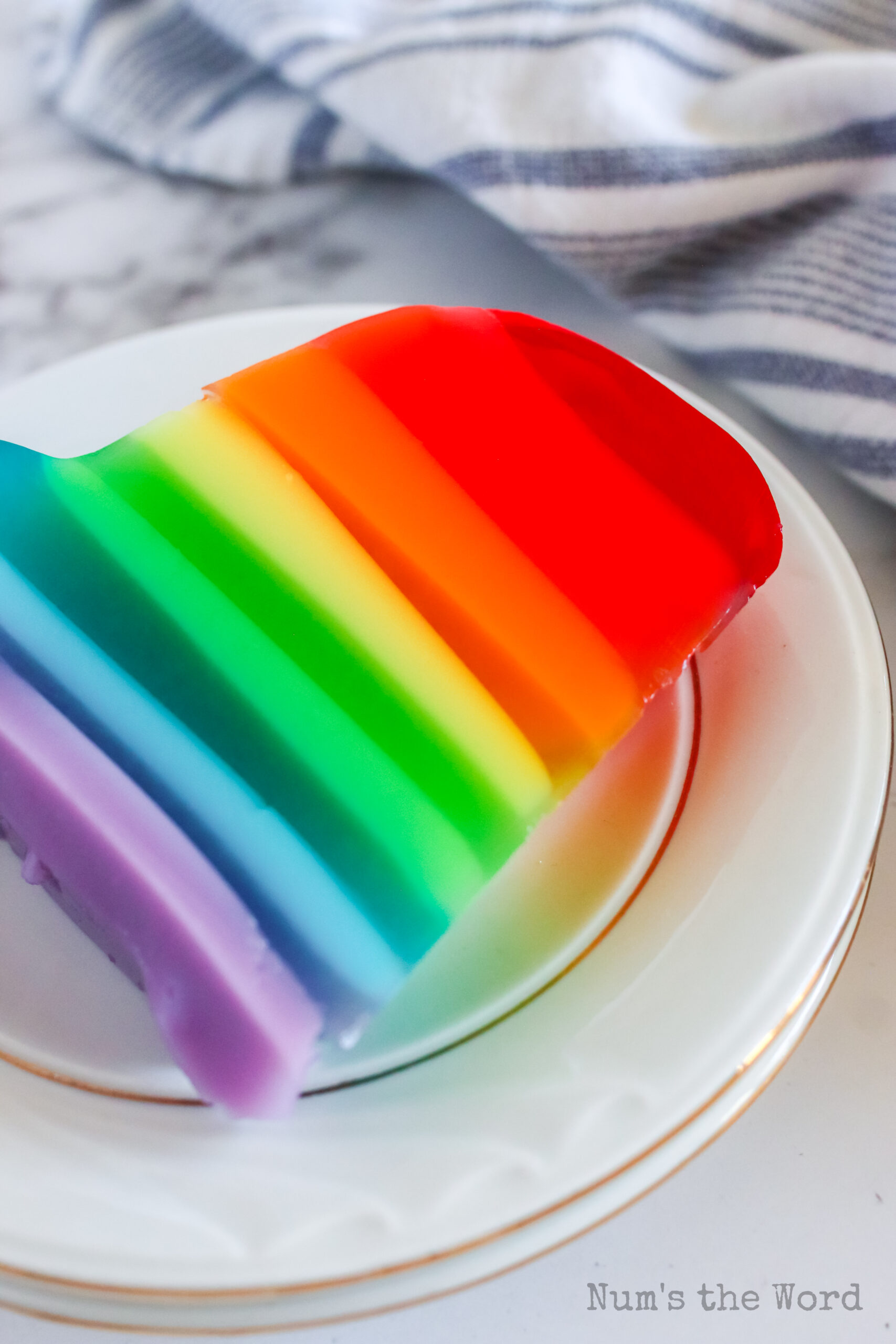 A slice of jello on a plate, showing layers.