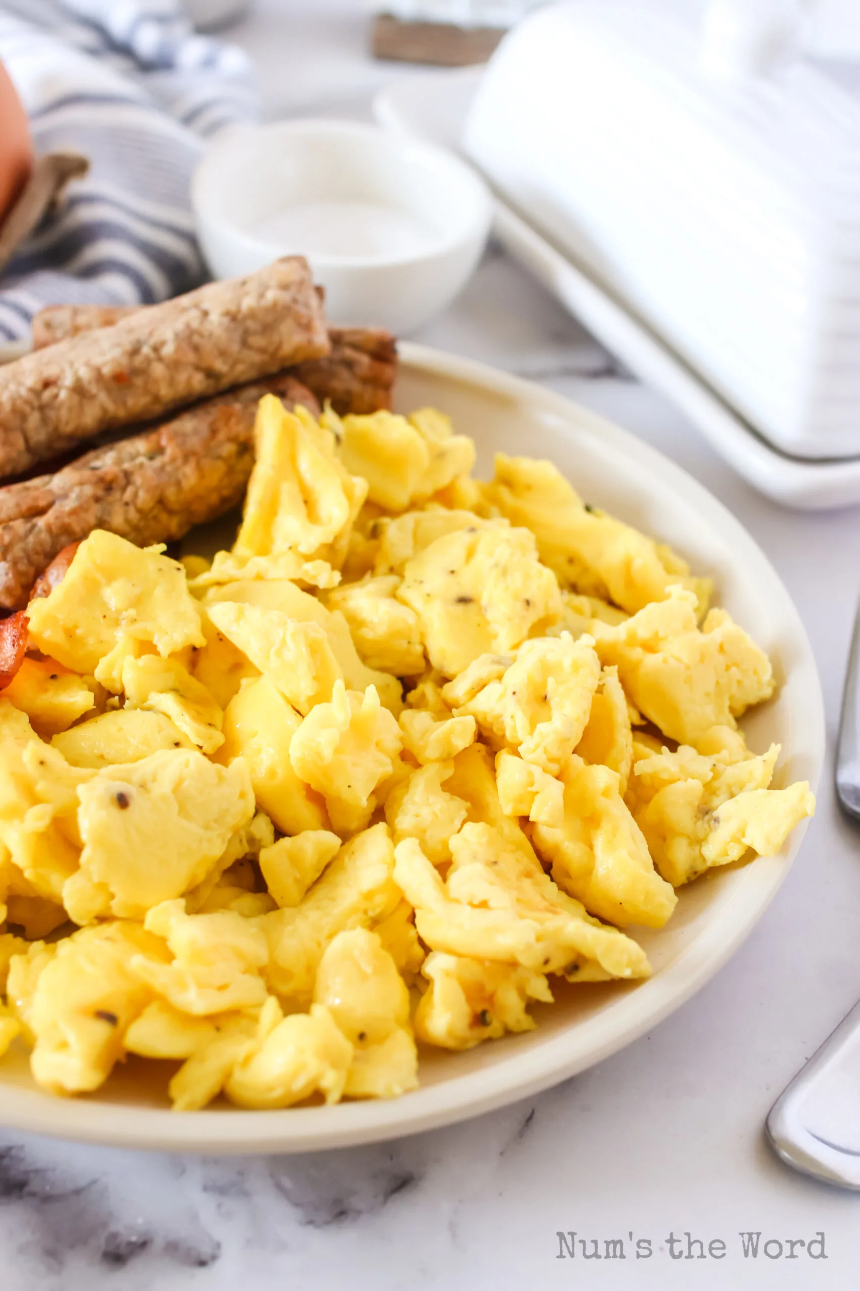 side view of eggs on a plate with sausage