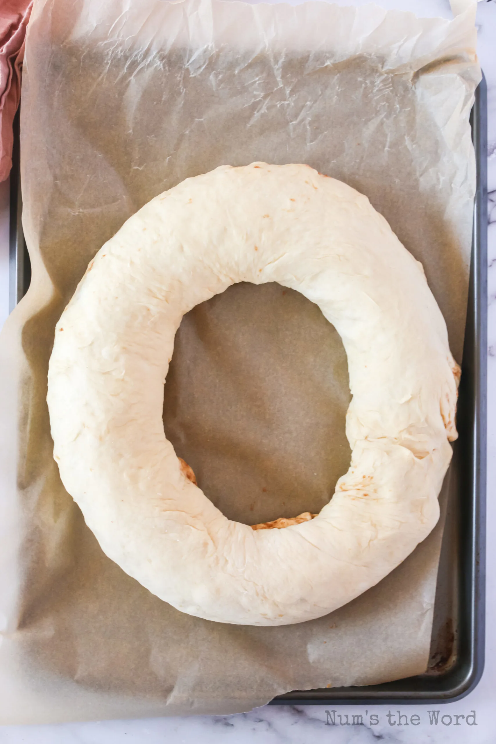 ends of roll pinched together to make a wreath and placed on a lined cookie sheet.