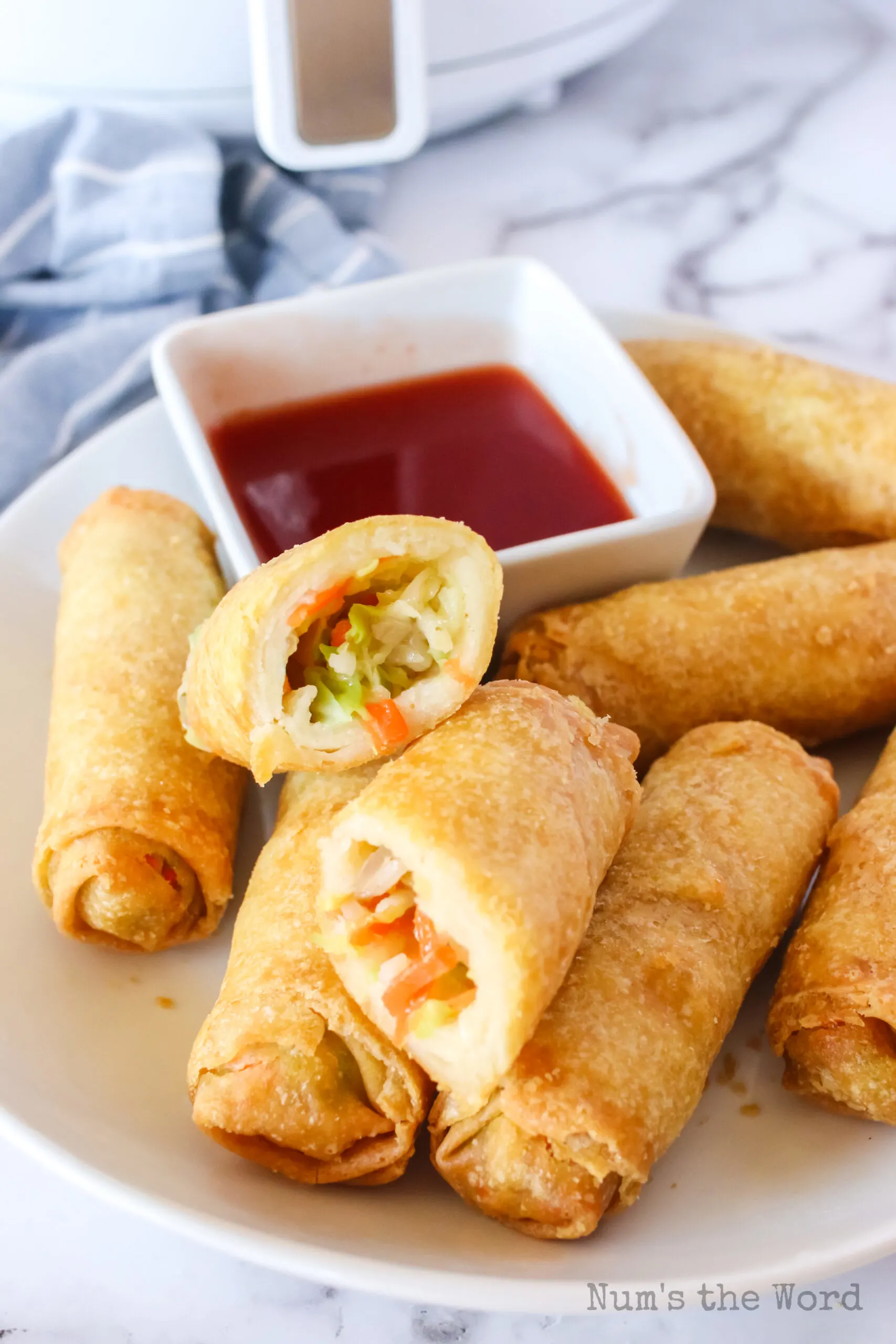 side view of egg rolls on plate with one cut in half