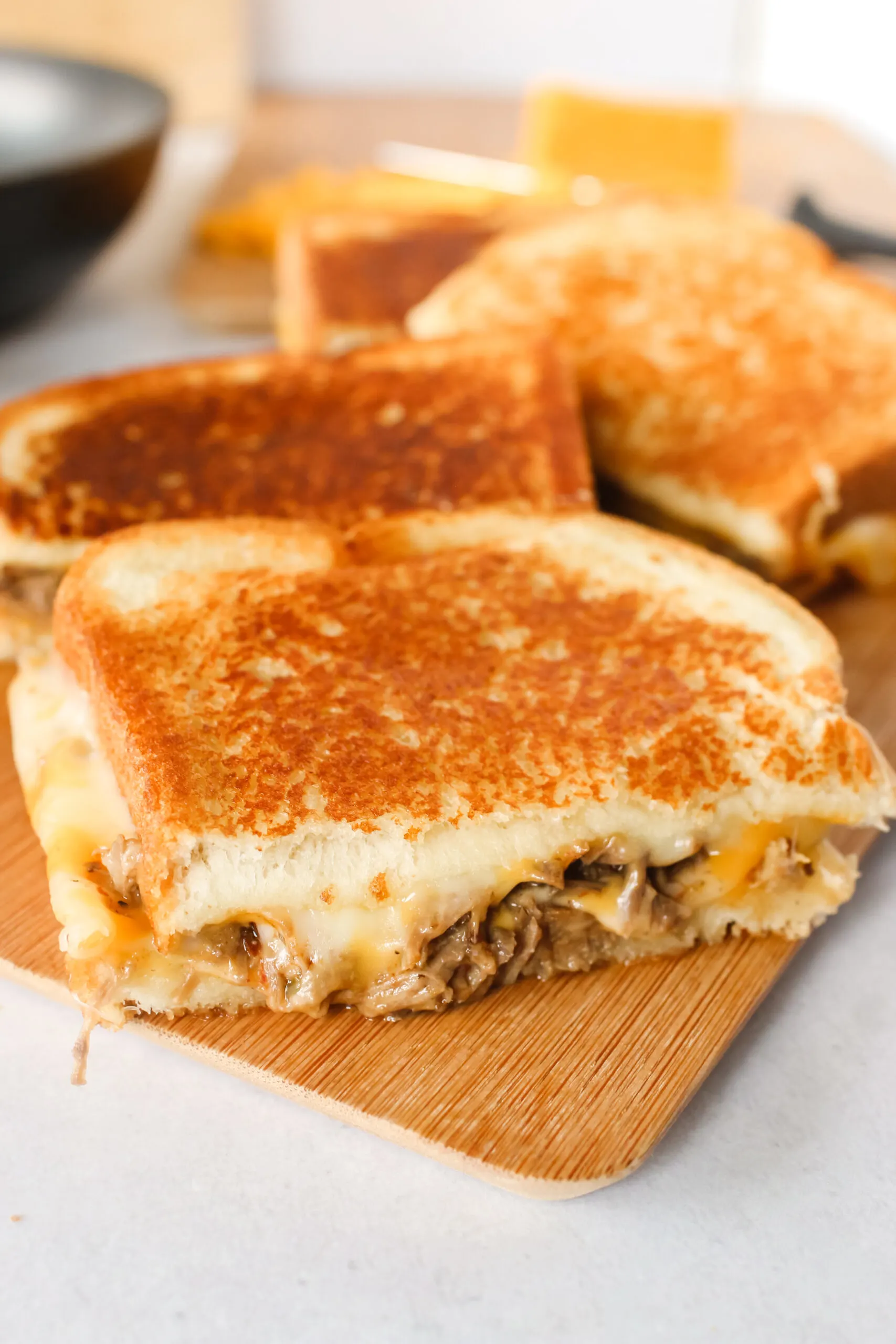 sliced grilled cheese on cutting board, side view