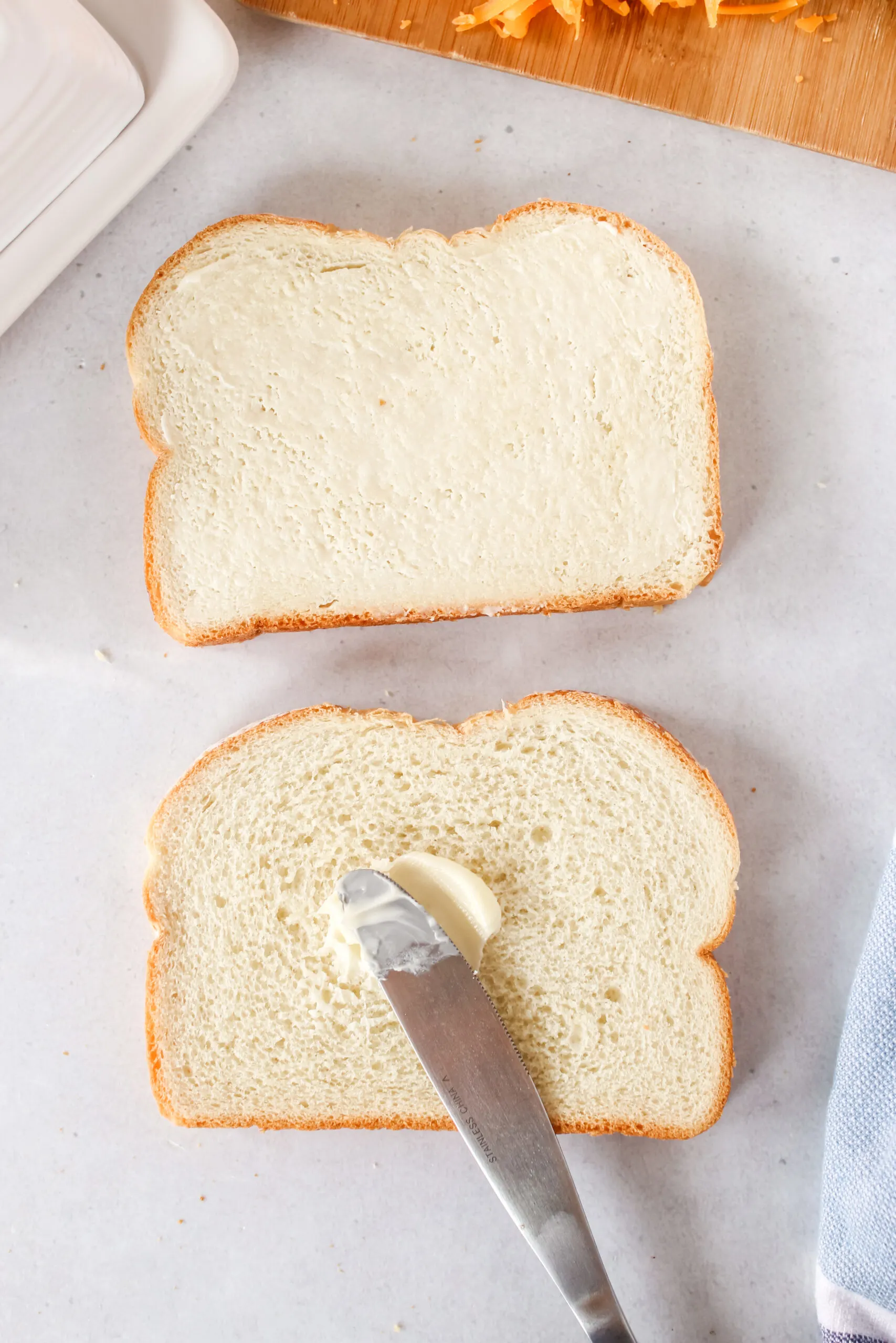 buttering one side of two slices of bread