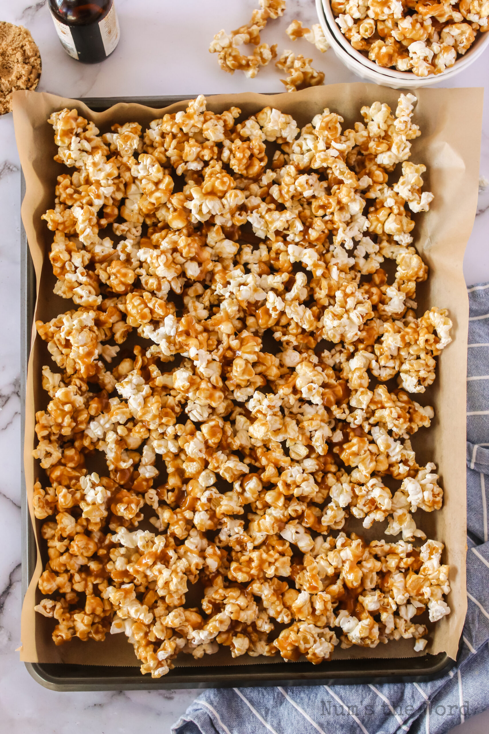 caramel corn placed on a cookie sheet with parchment paper