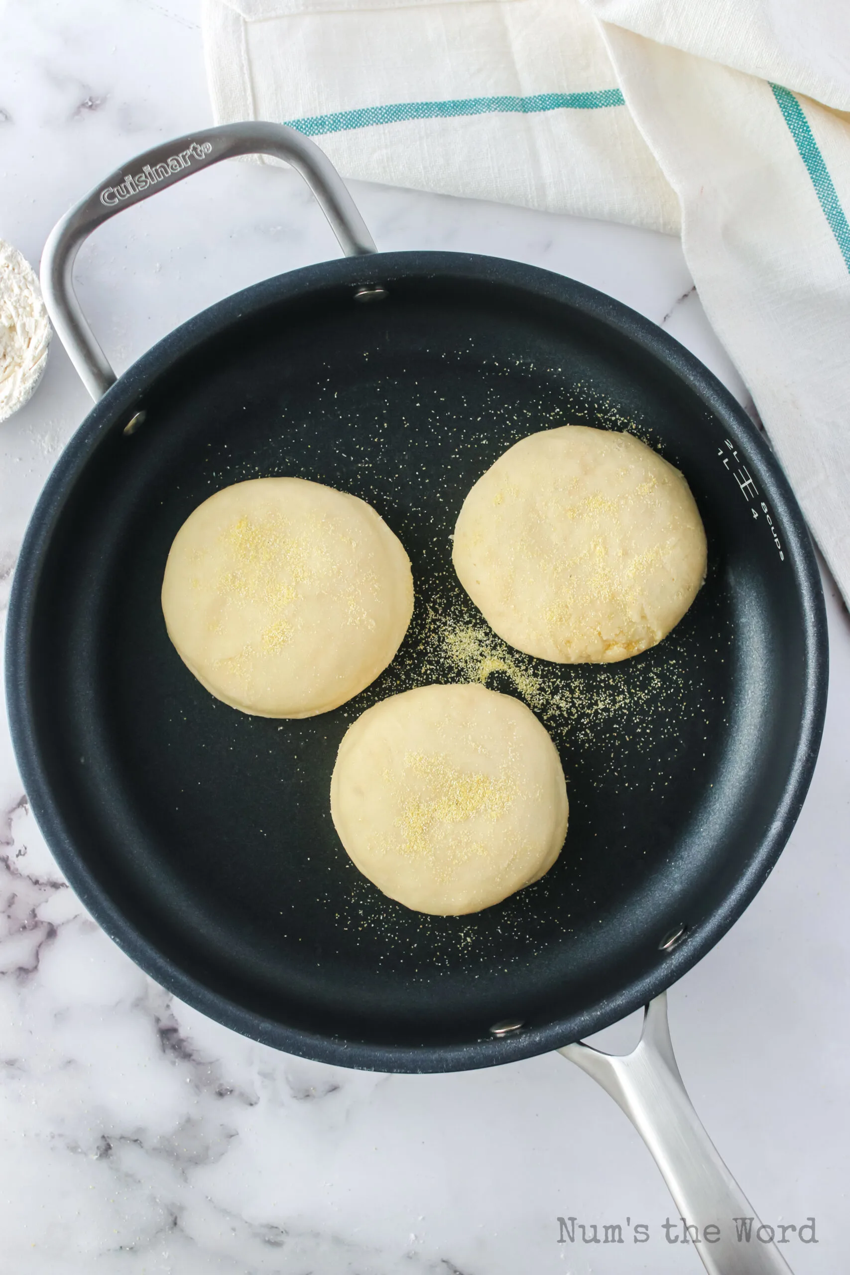 english muffins in a skillet, cooking.