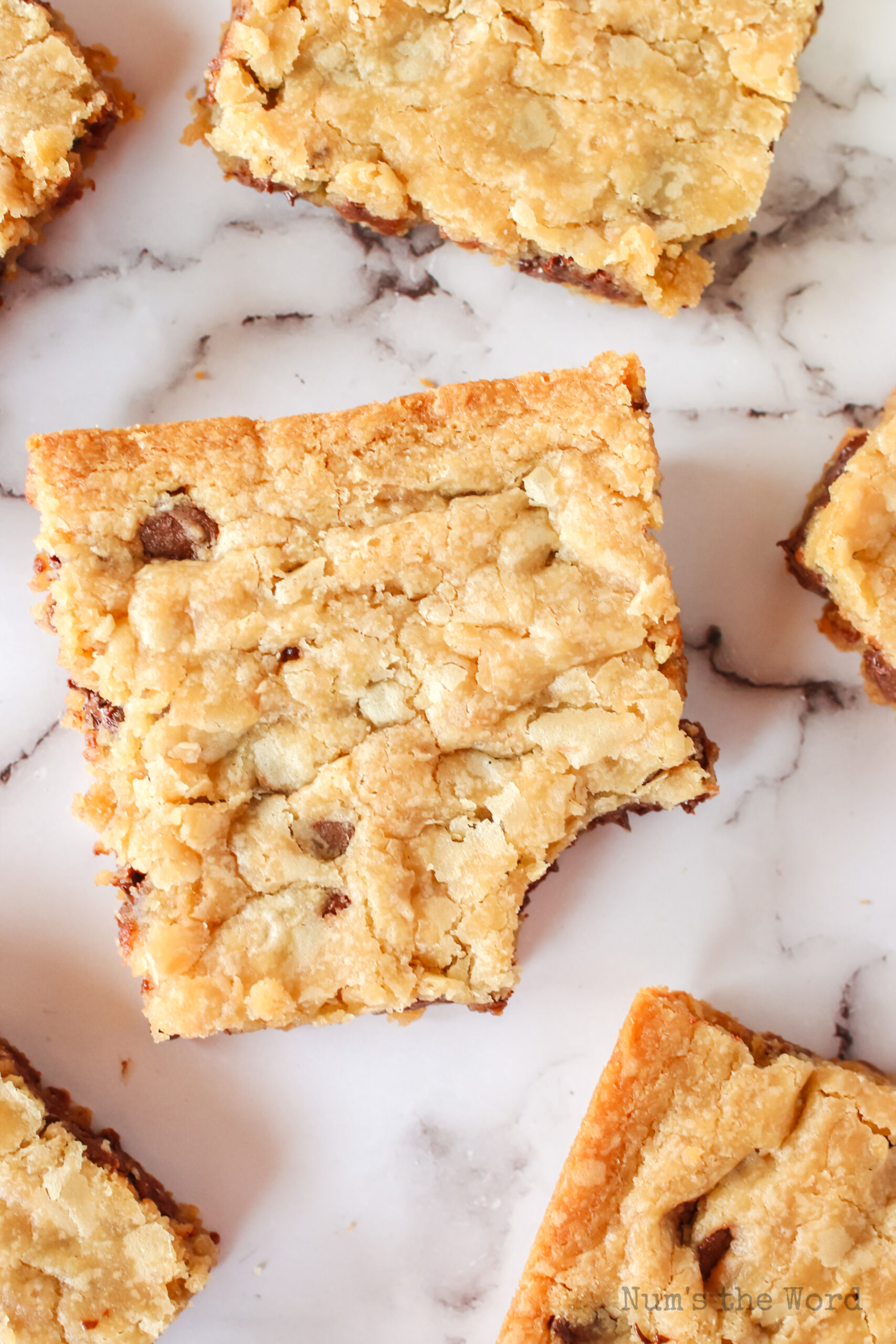 zoomed in cookie bars spread out with one missing a bite.
