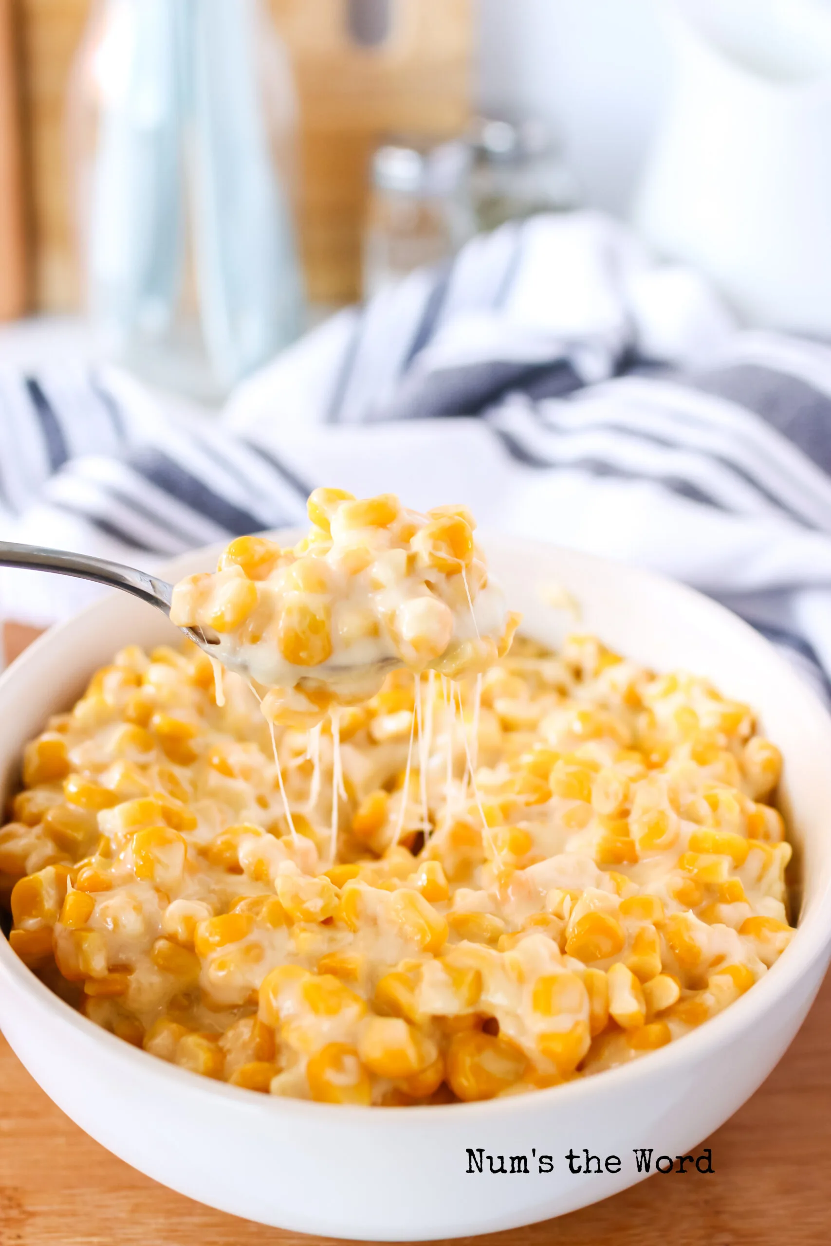 spoon scooping up creamed corn with a cheese pull