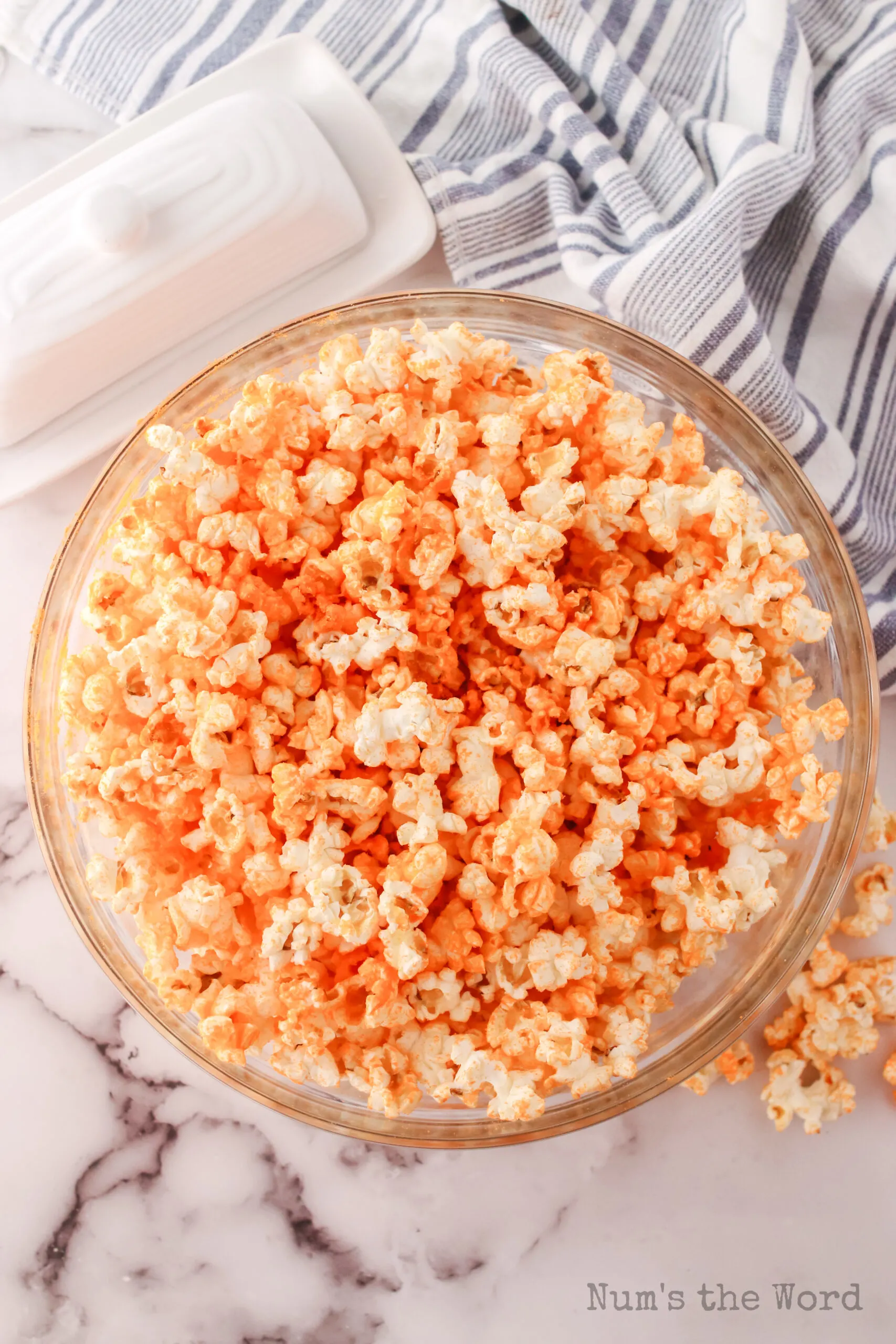 popcorn mixed with butter and cheese powder in a bowl.