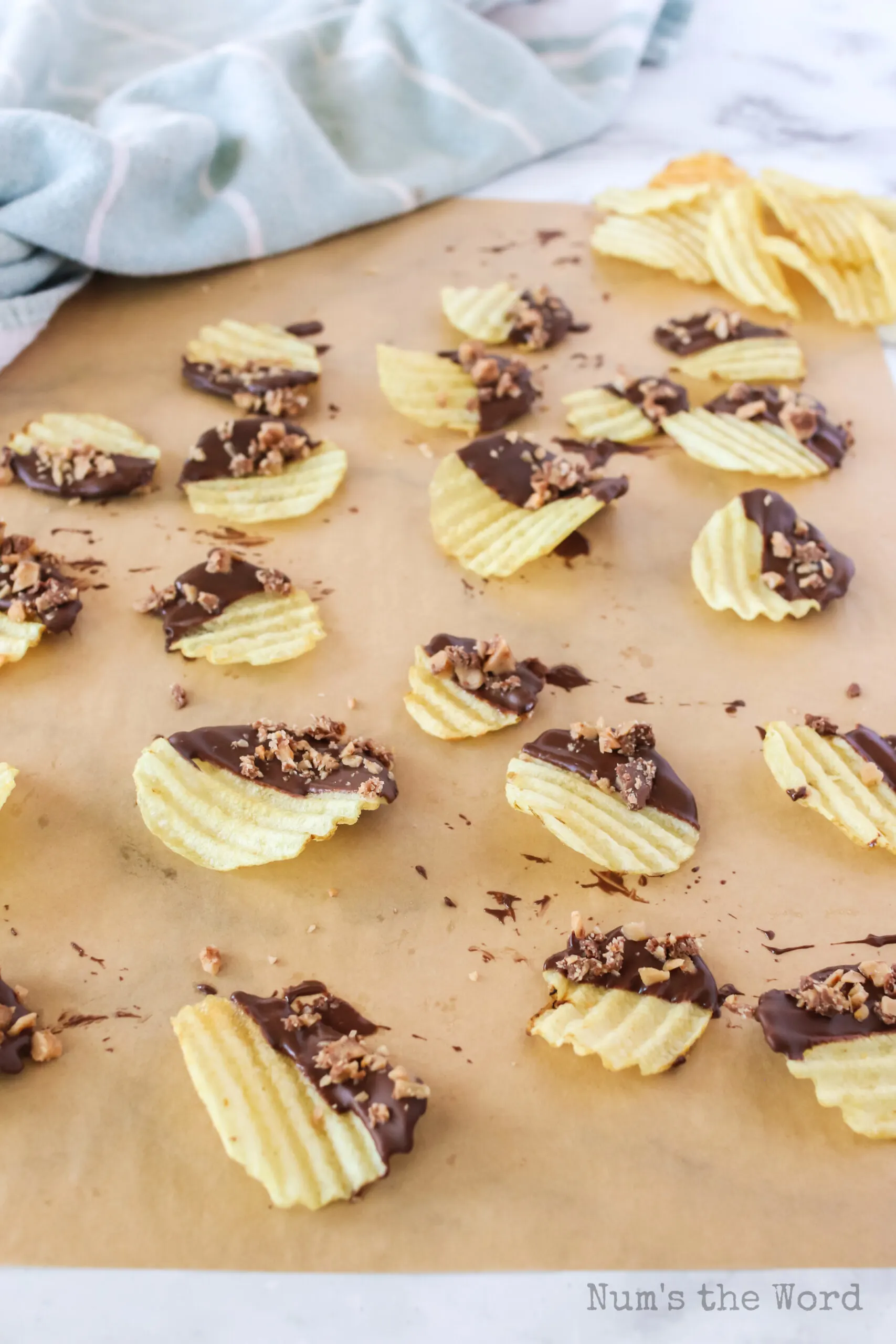 chocolate potato chips on parchment paper with sprinkled crushed heath bars