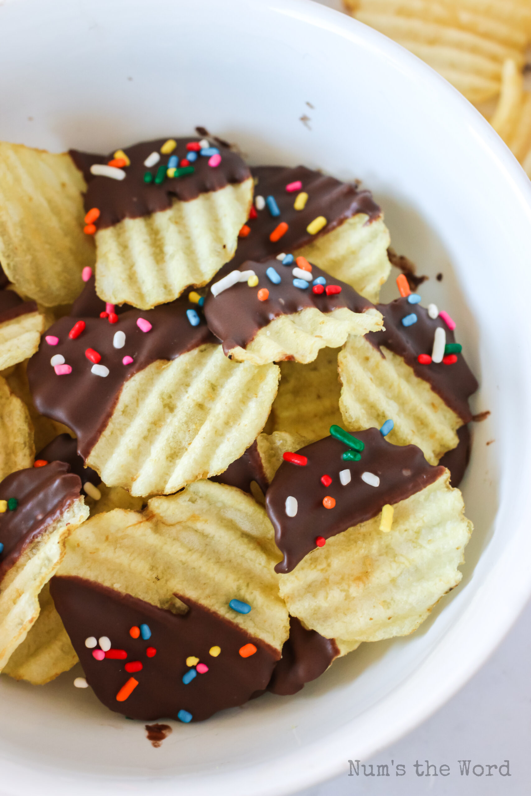 close up of chips in a bowl with chocolate and colored sprinkles