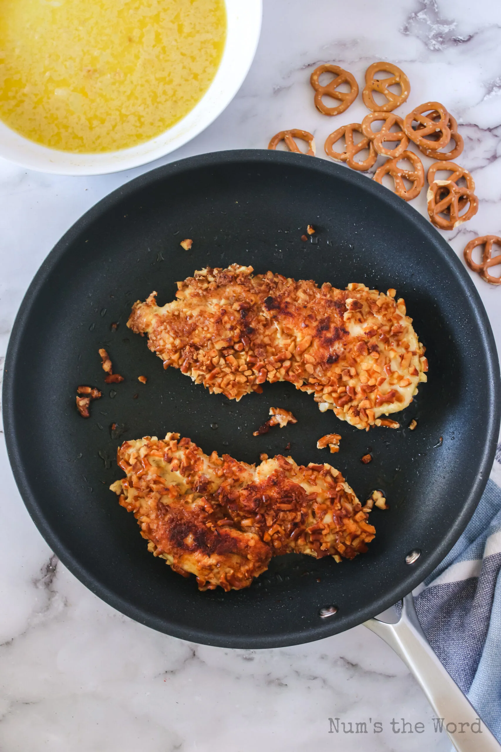 chicken breasts have been cooked on one side, and have been flipped to cook second side.