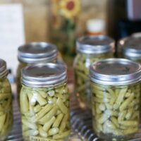 6 jars of canned green beans on counter.