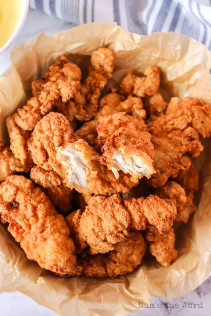 chicken strips in basket with one cut in half.