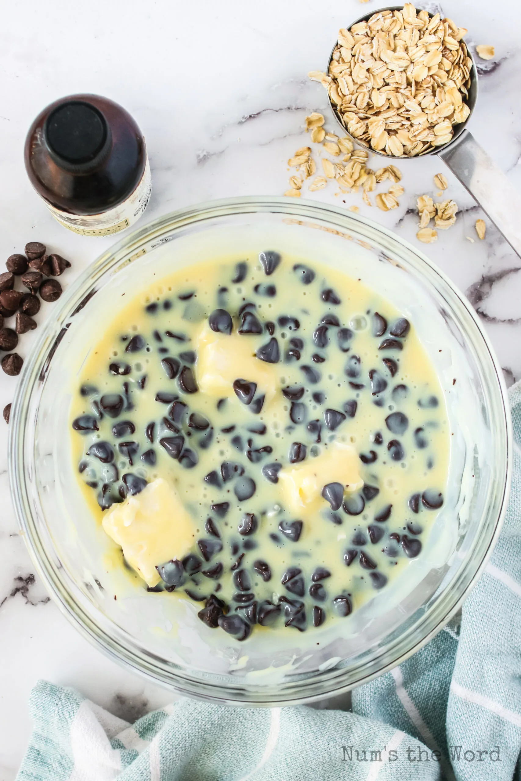 chocolate chips, sweetened condensed milk, butter and vanilla extract added to a bowl.