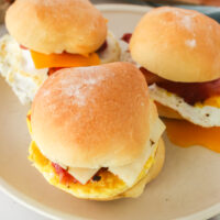 3 breakfast sandwiches on a plate, ready to eat