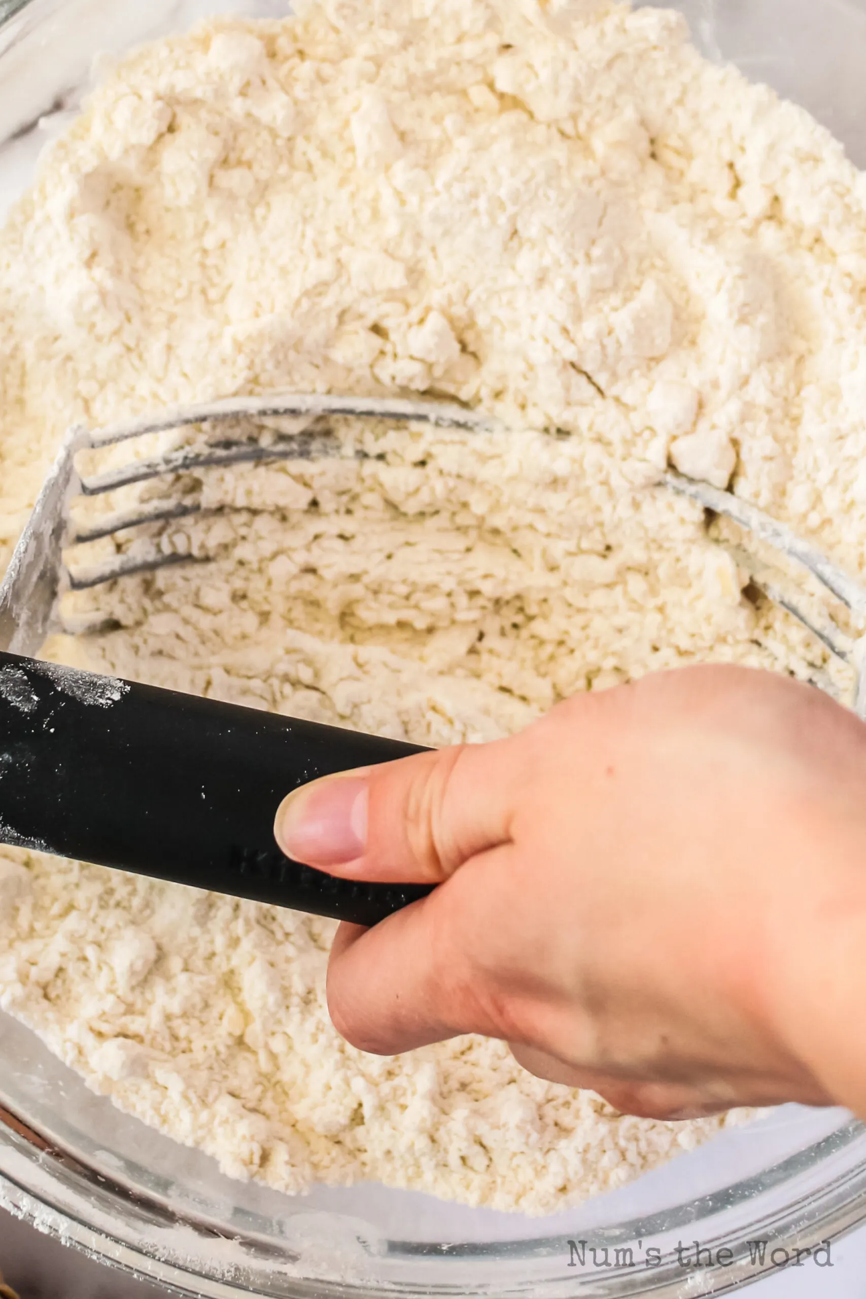 Pastry blender mixing waffle dough together.