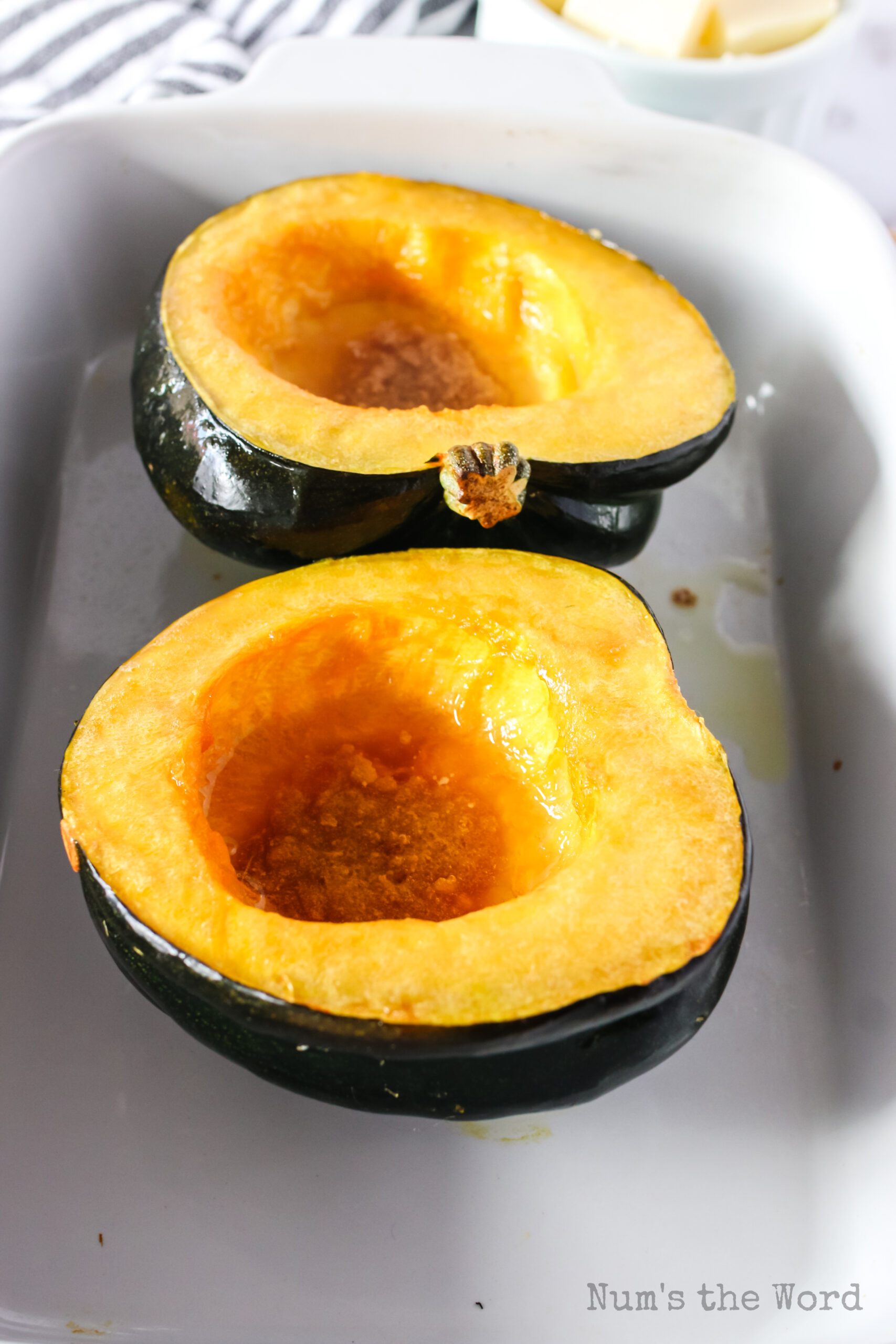 two squash halves in a casserole dish fresh from the oven