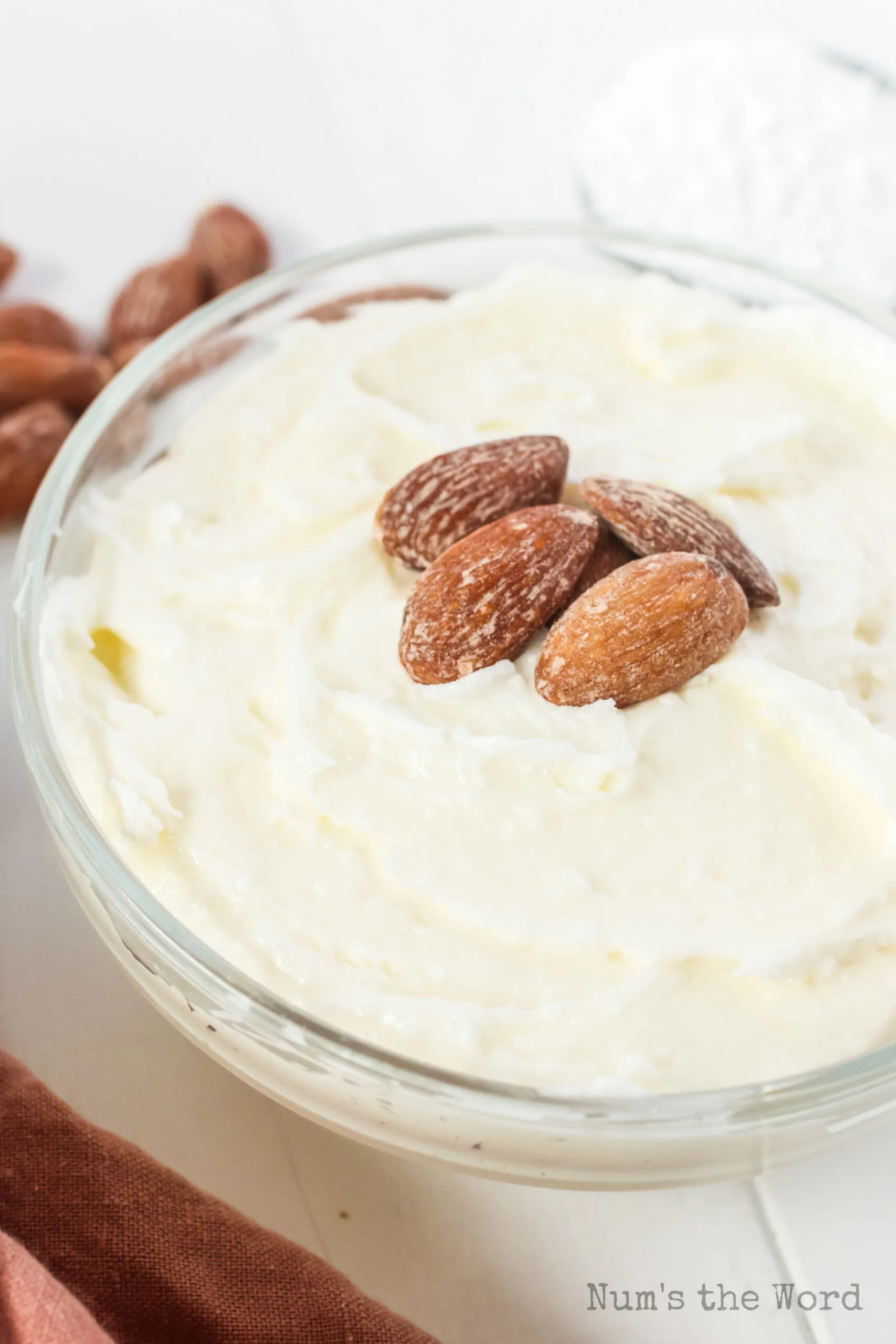 top side view of frosting a bowl with 4 almonds on top