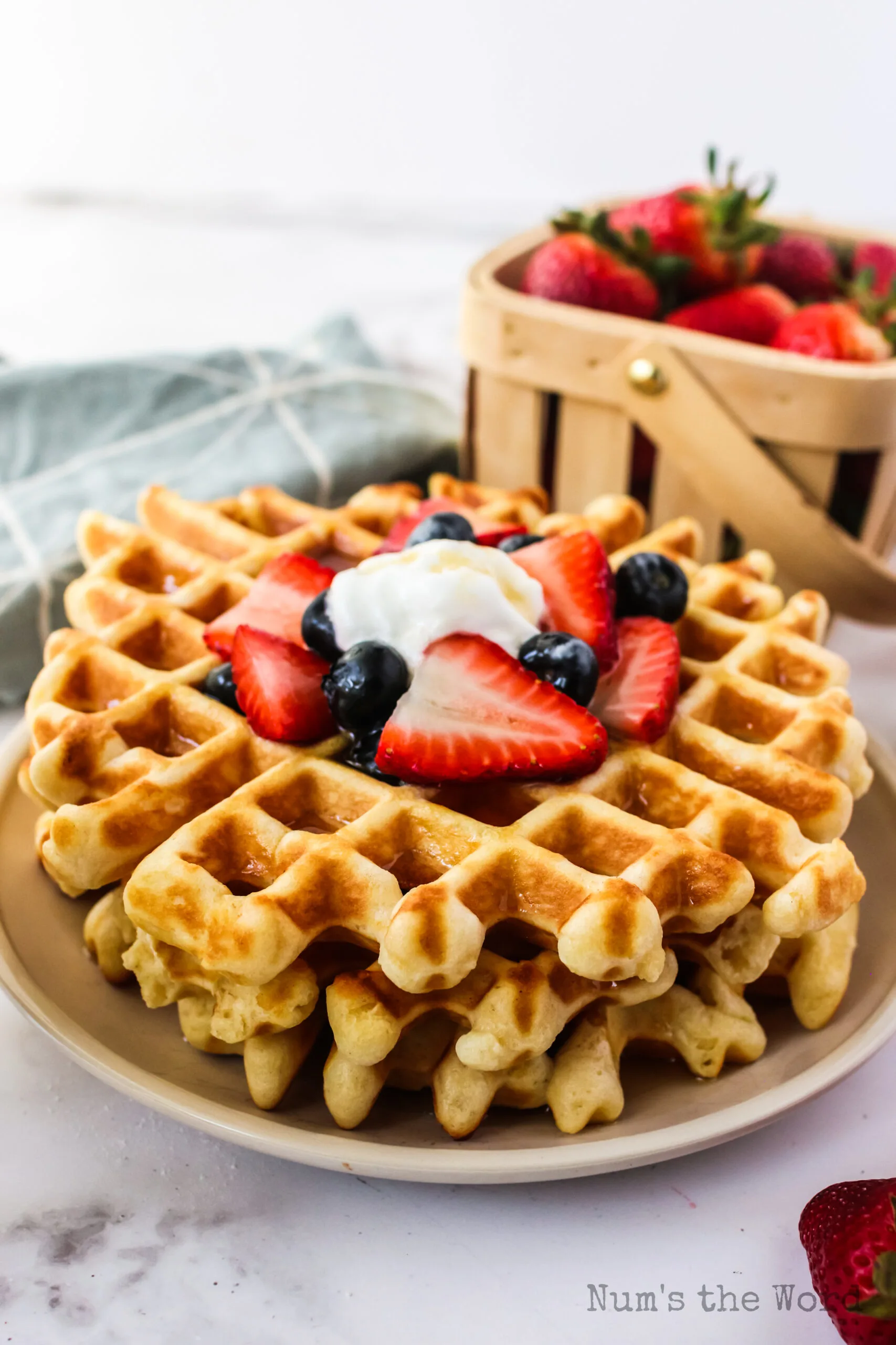 side view of fresh fruit on top of waffle with a little butter too