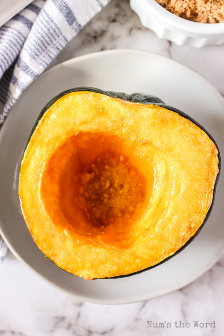 zoomed in image of squash half on plate with butter brown sugar mixture in the center well.