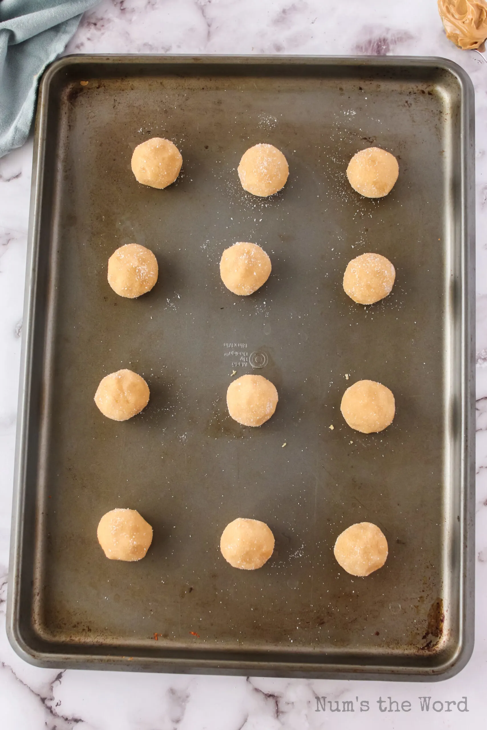 12 sugar coated dough balls on a cookie sheet