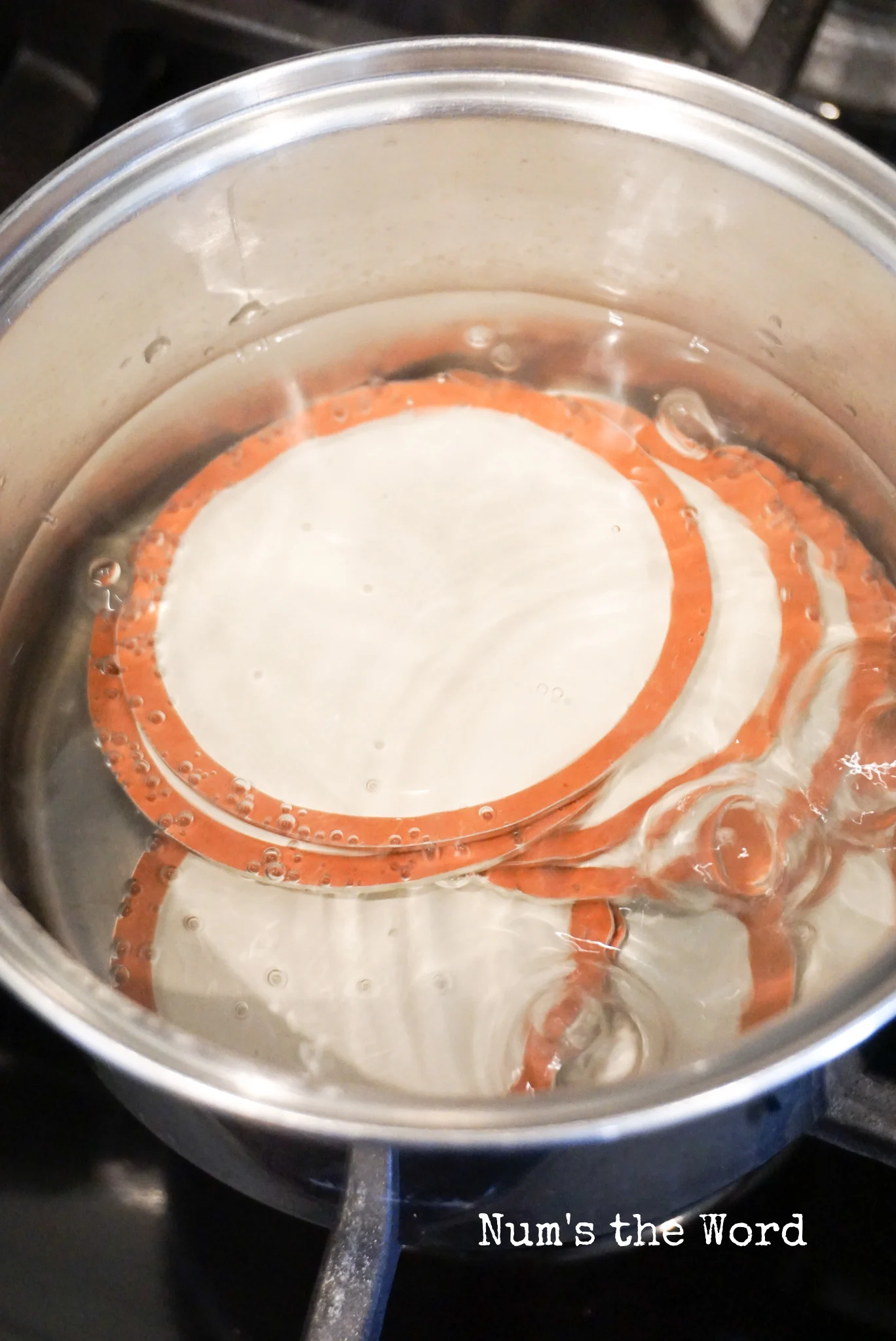 canning lids in a pot, boiling