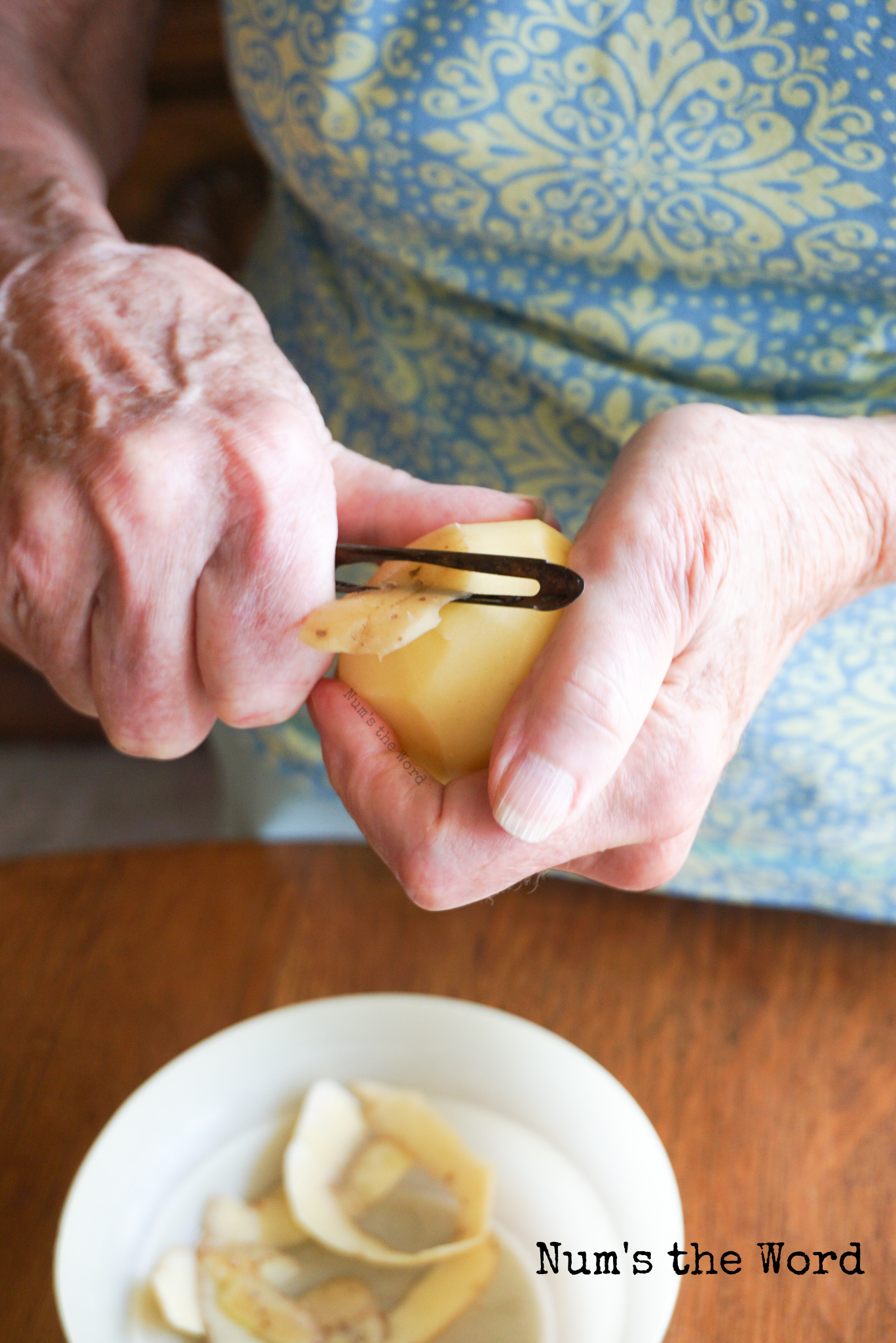 hands peeling potatoes