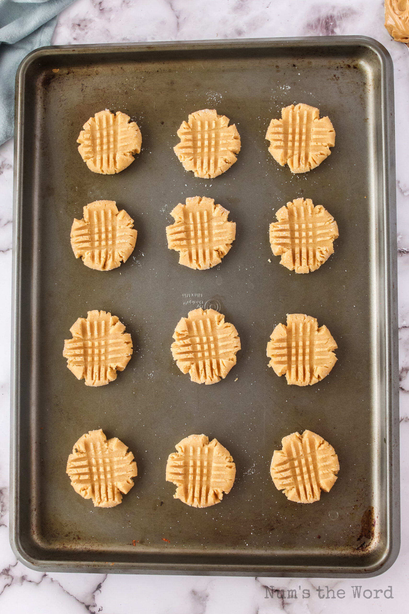 criss crossed fork prints on peanut butter cookies before they are baked