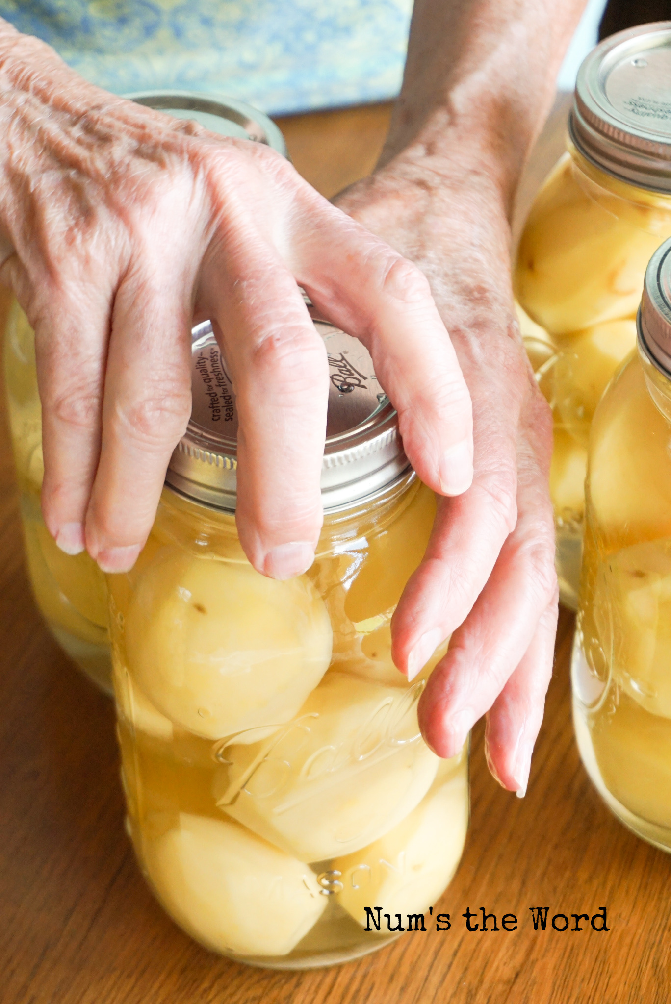 hand screwing a ring onto the canning jar