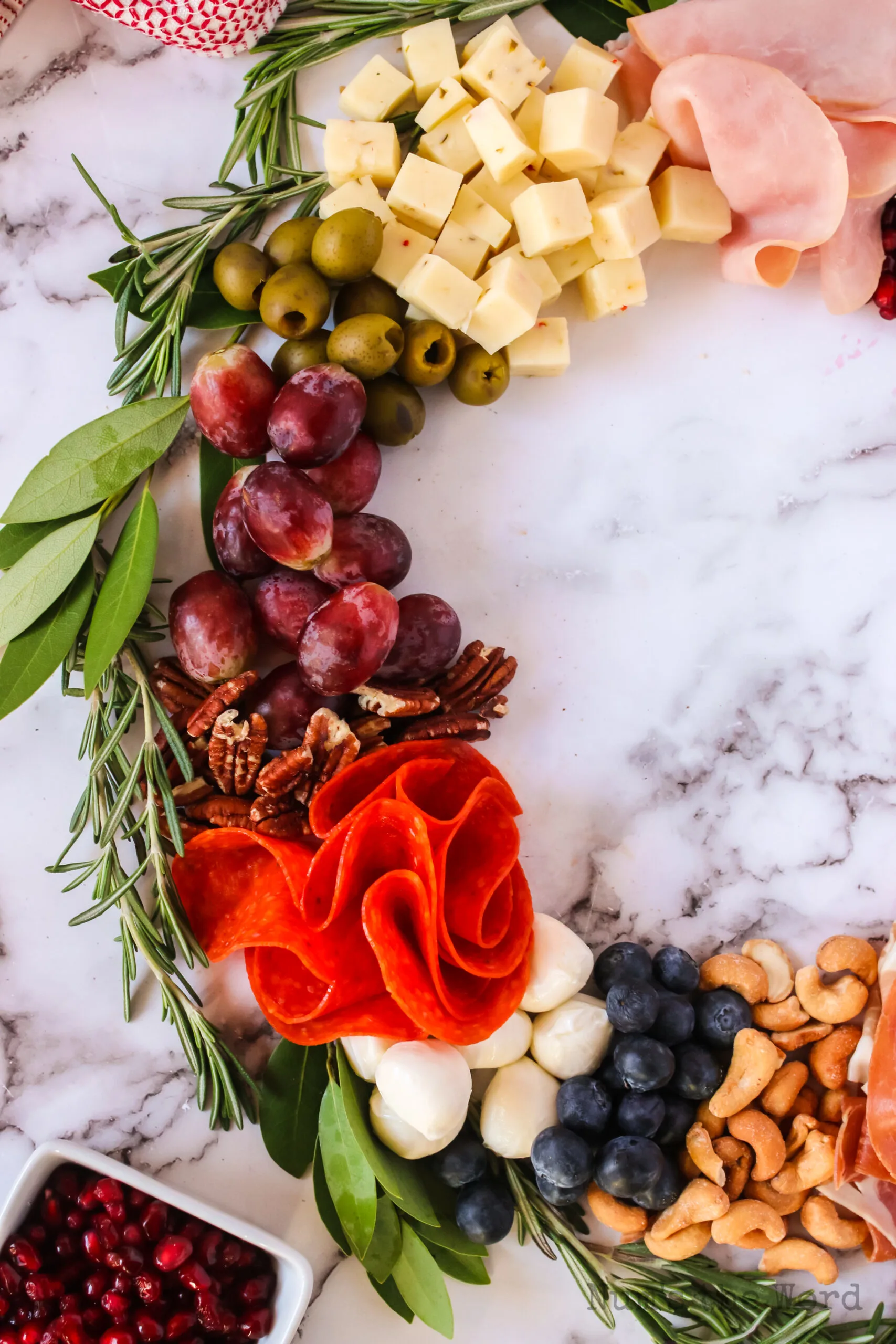 1/2 the charcuterie wreath. Cashews, blueberries, mozzarella balls, pepperoni, pecans, red grapes, green olives, pepper jack cheese and ham