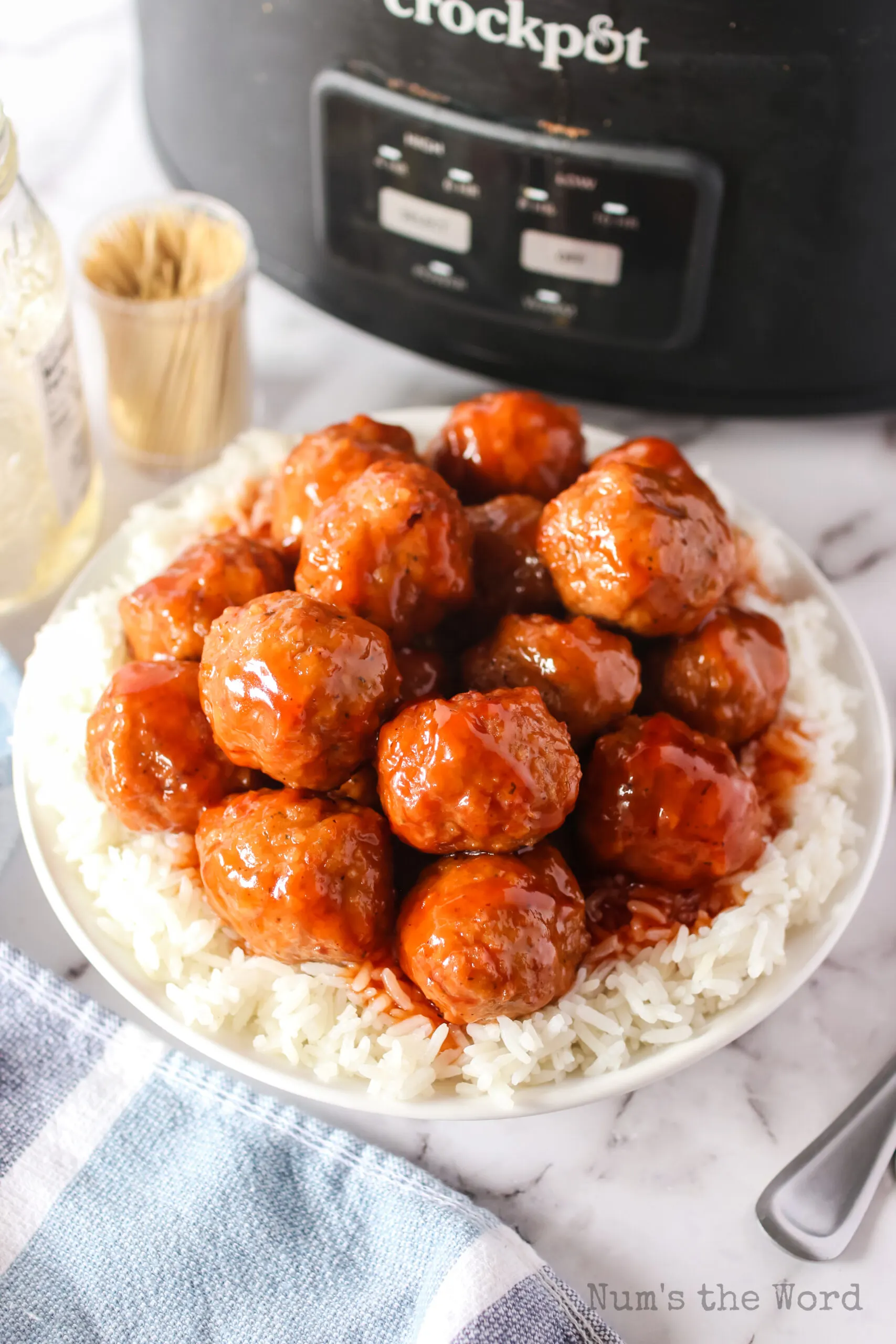 meatballs stacked up on a plate on a bed of rice.