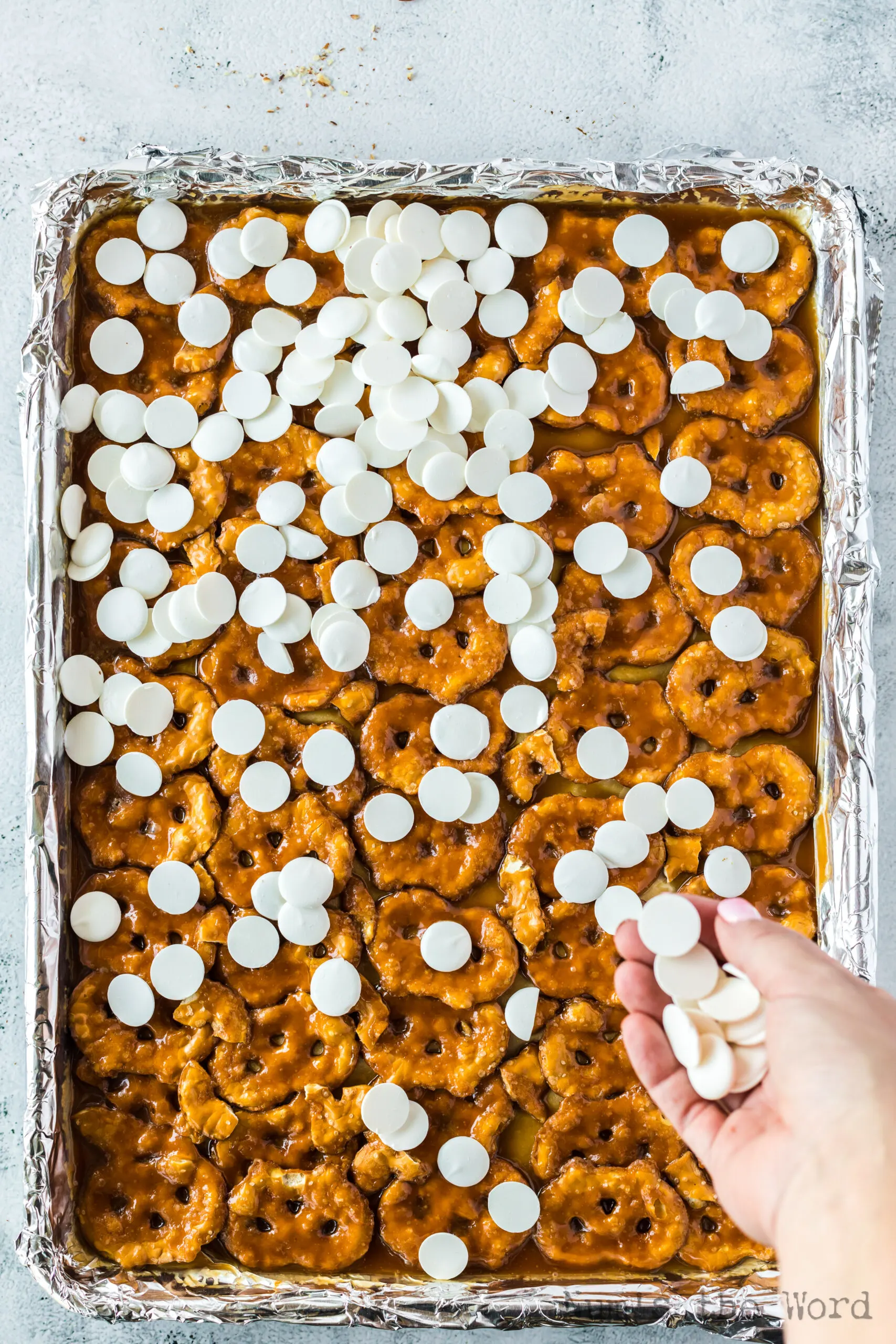 White chocolate chips sprinkled all over caramel pretzels
