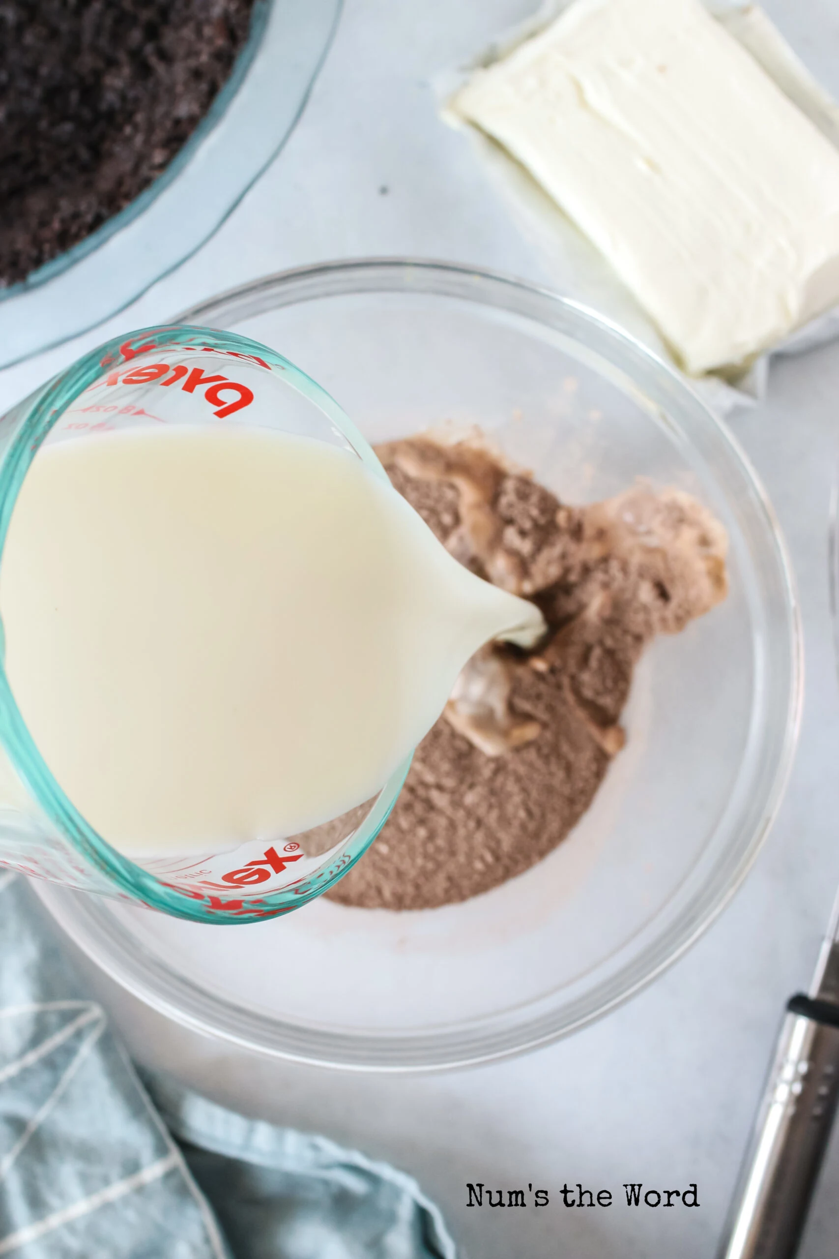 milk being poured into a bowl with dry chocolate pudding