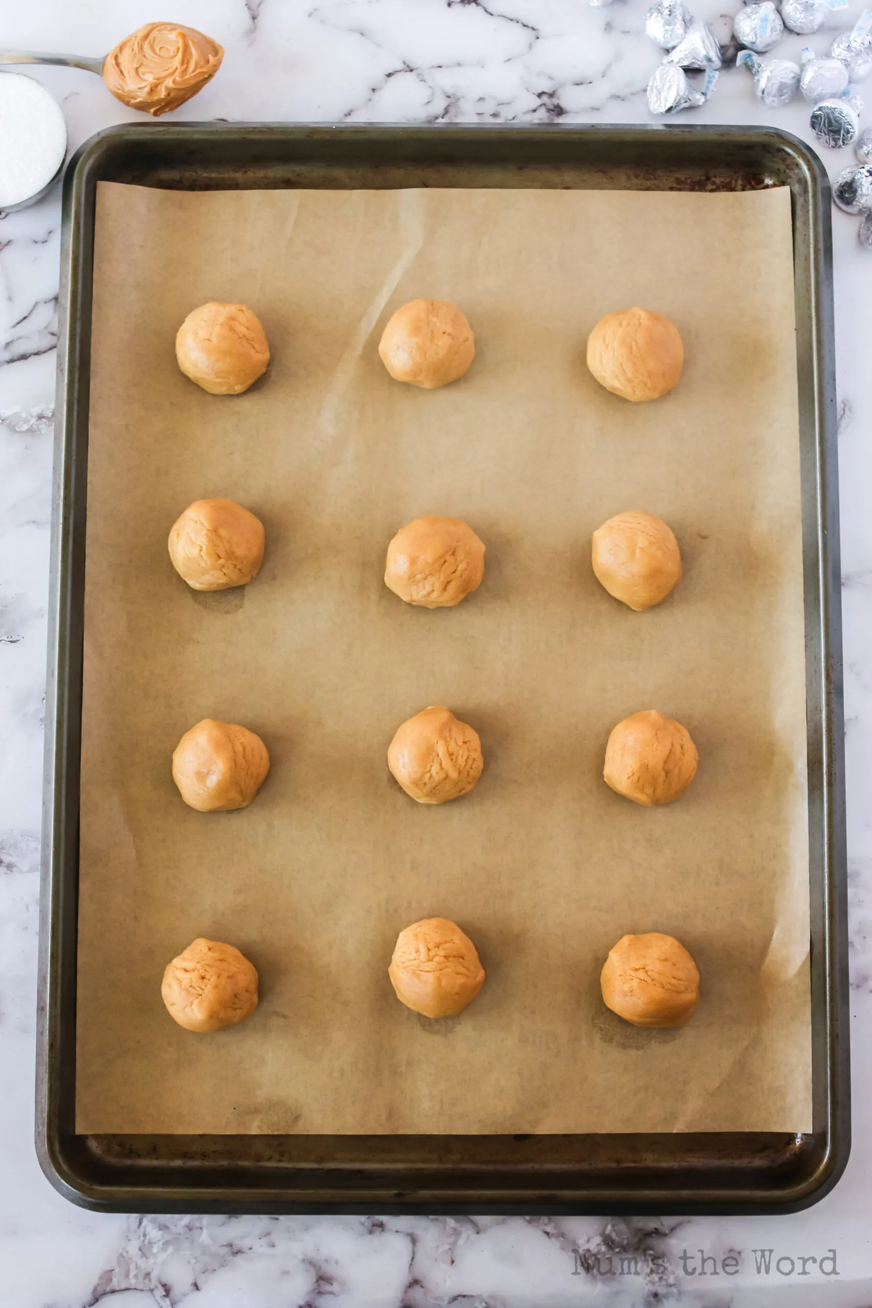 12 round peanut butter balls on cookie sheet