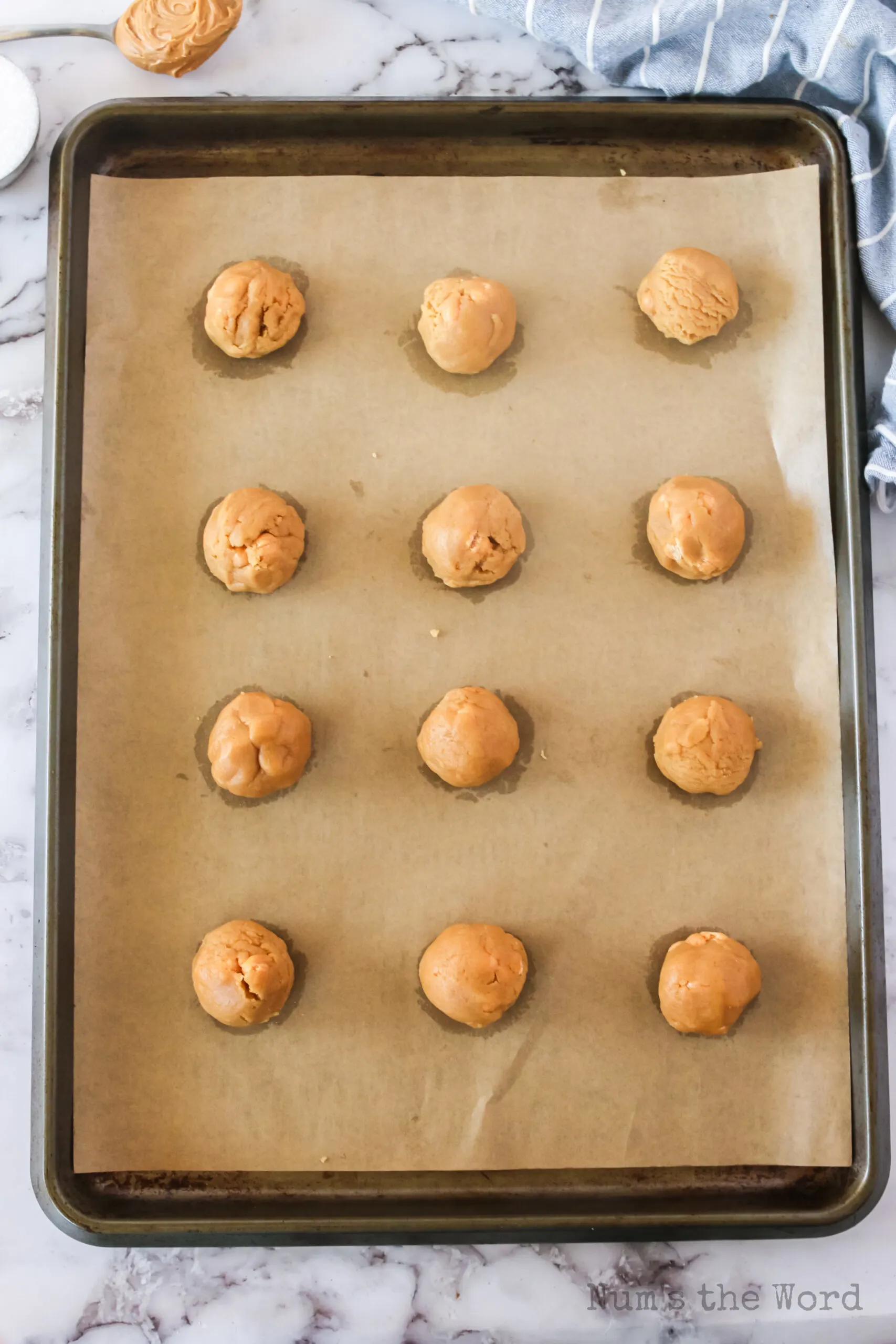 12 balls of cookie dough on a cookie sheet