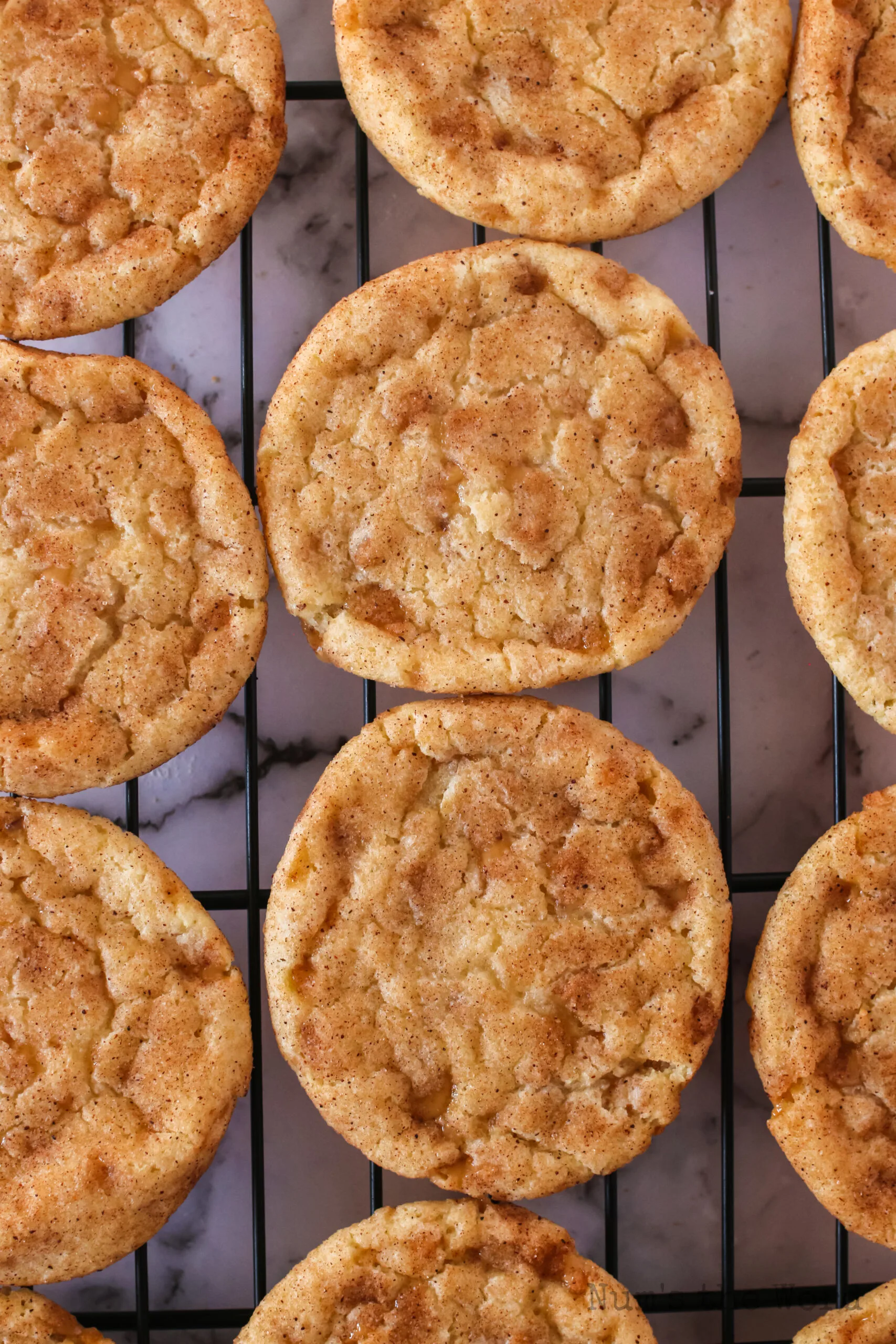 zoomed in image of cookies on a cooling rack showing off toffee bits